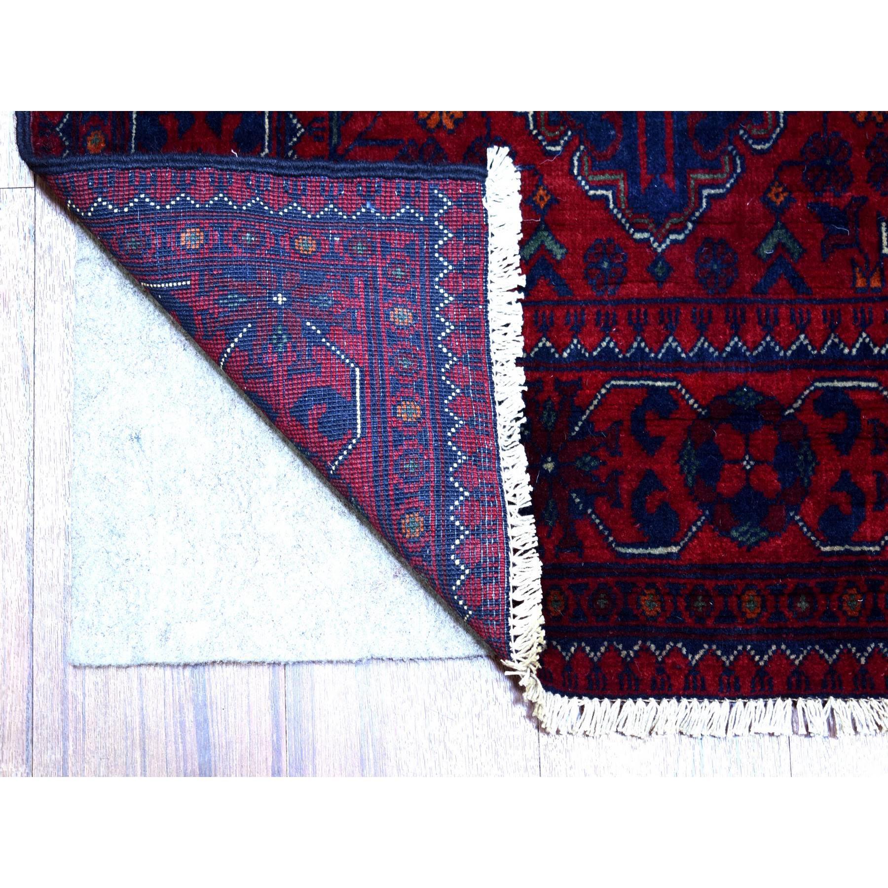 Si tratta di un autentico esemplare unico di rosso intenso e saturo con un mix di blu navy, Khamyab afgano annodato a mano con medaglioni geometrici, pura lana, tappeto orientale Runner. È stato annodato per mesi e mesi in una tessitura