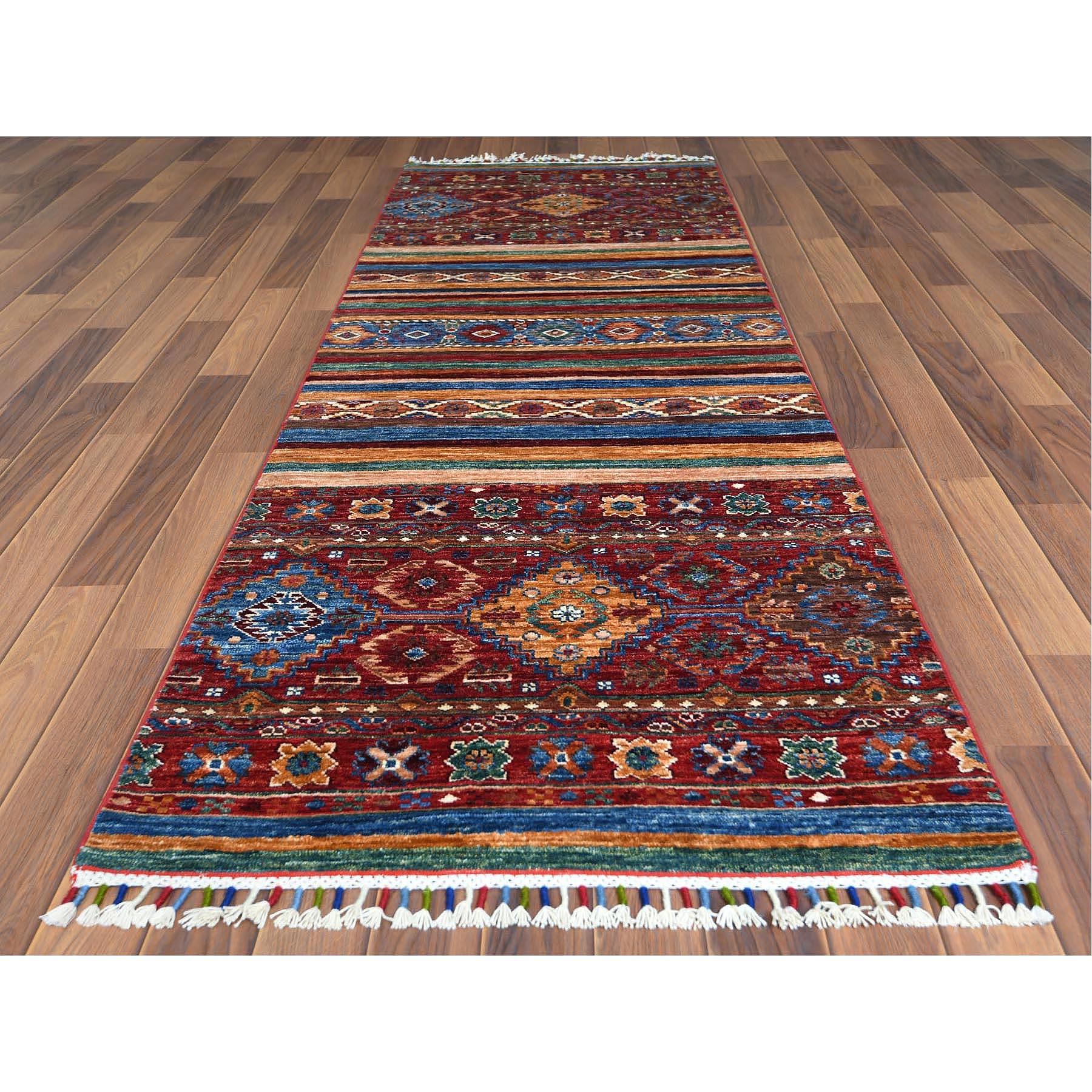 This is a truly genuine one-of-a-kind Red Super Kazak Khorjin Design With Colorful Tassles Soft Velvety Wool Hand Knotted Oriental Runner Rug. It has been Knotted for months and months in the centuries-old Persian weaving craftsmanship techniques by