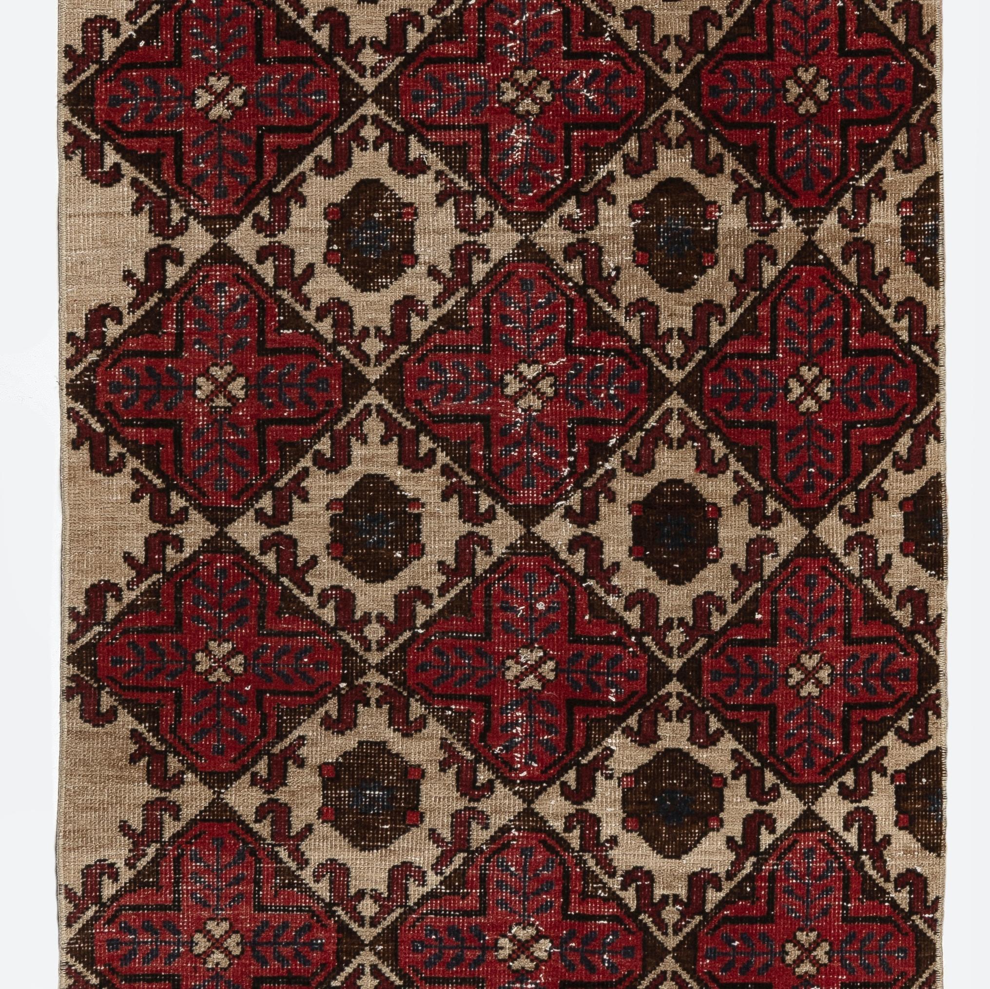 A vintage Turkish runner rug in red, beige, brown & navy blue. It was hand-knotted in the 1960s with low wool on cotton foundation and features a geometric design. It is in very good condition, professionally-washed, sturdy and suitable for areas