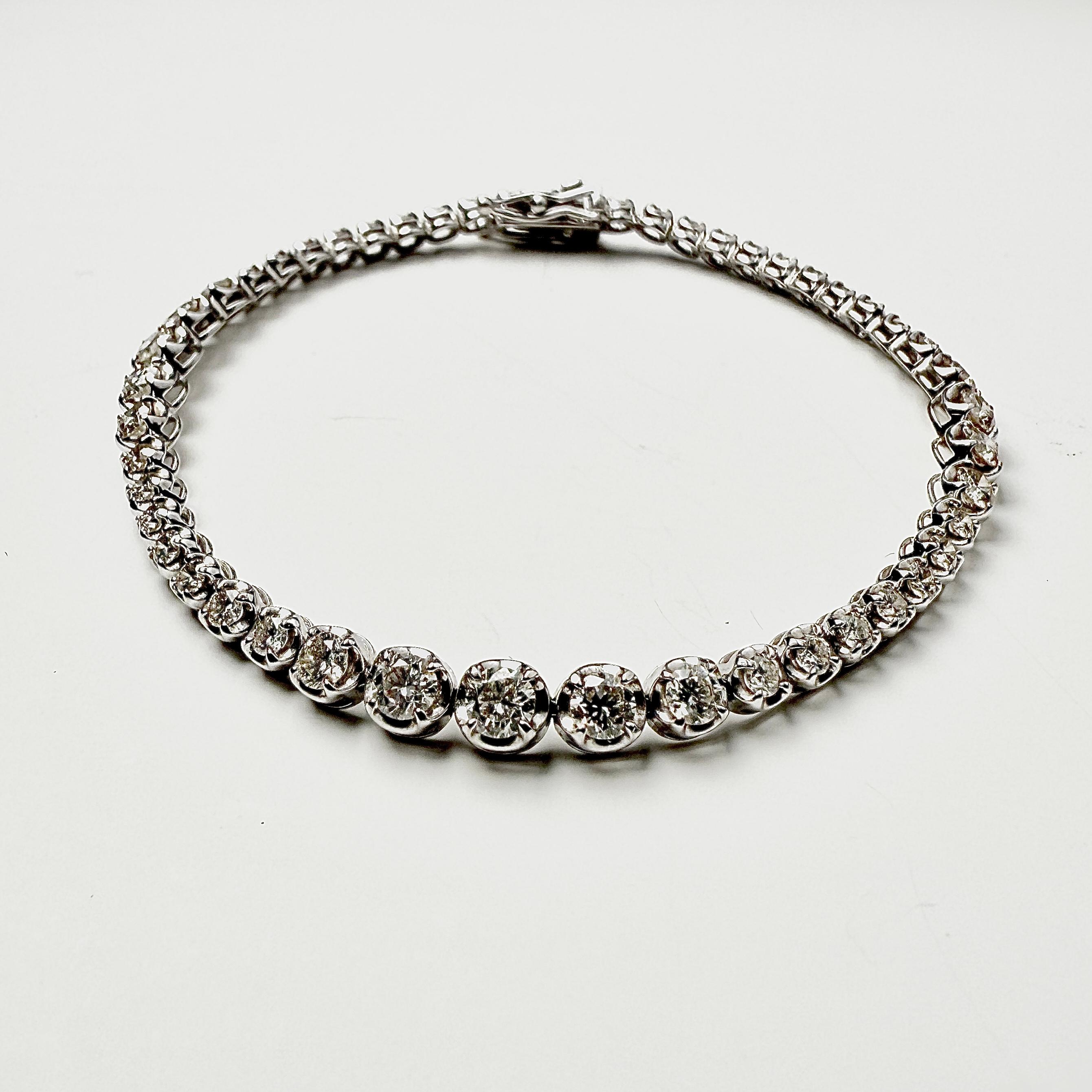 Pulsera Sinfónica Graduada de Diamantes: Una Declaración Elegante

Esta exquisita pulsera ofrece un giro lujoso y único al clásico estilo tenis. Elaborado con maestría en reluciente Oro Blanco de 18 quilates, el diseño presenta una corriente