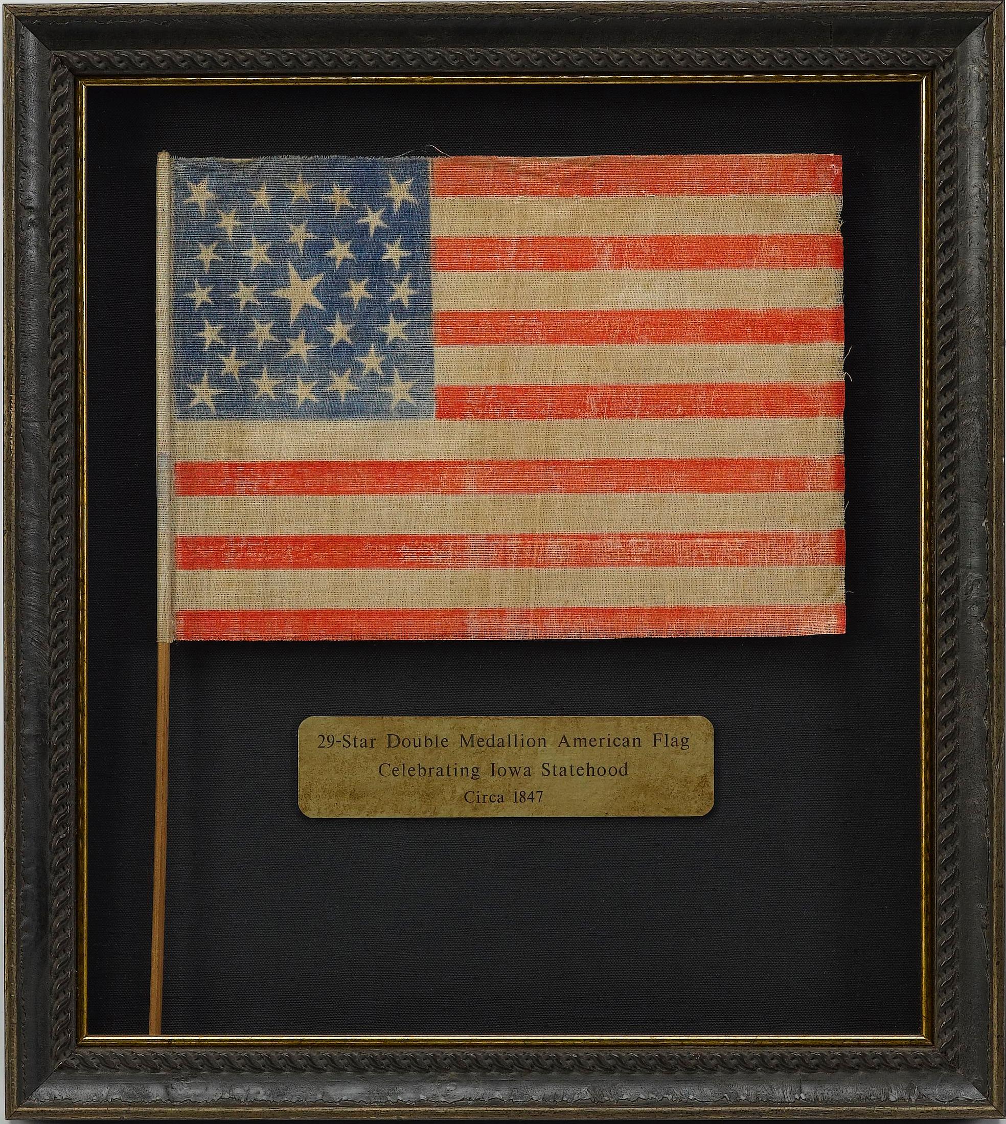 This is a rare 29-star medallion American flag, celebrating the addition of Iowa to the Union. The flag is printed on glazed muslin, and has a spectacularly unique star pattern. A double medallion of stars surrounds a large central star. The large