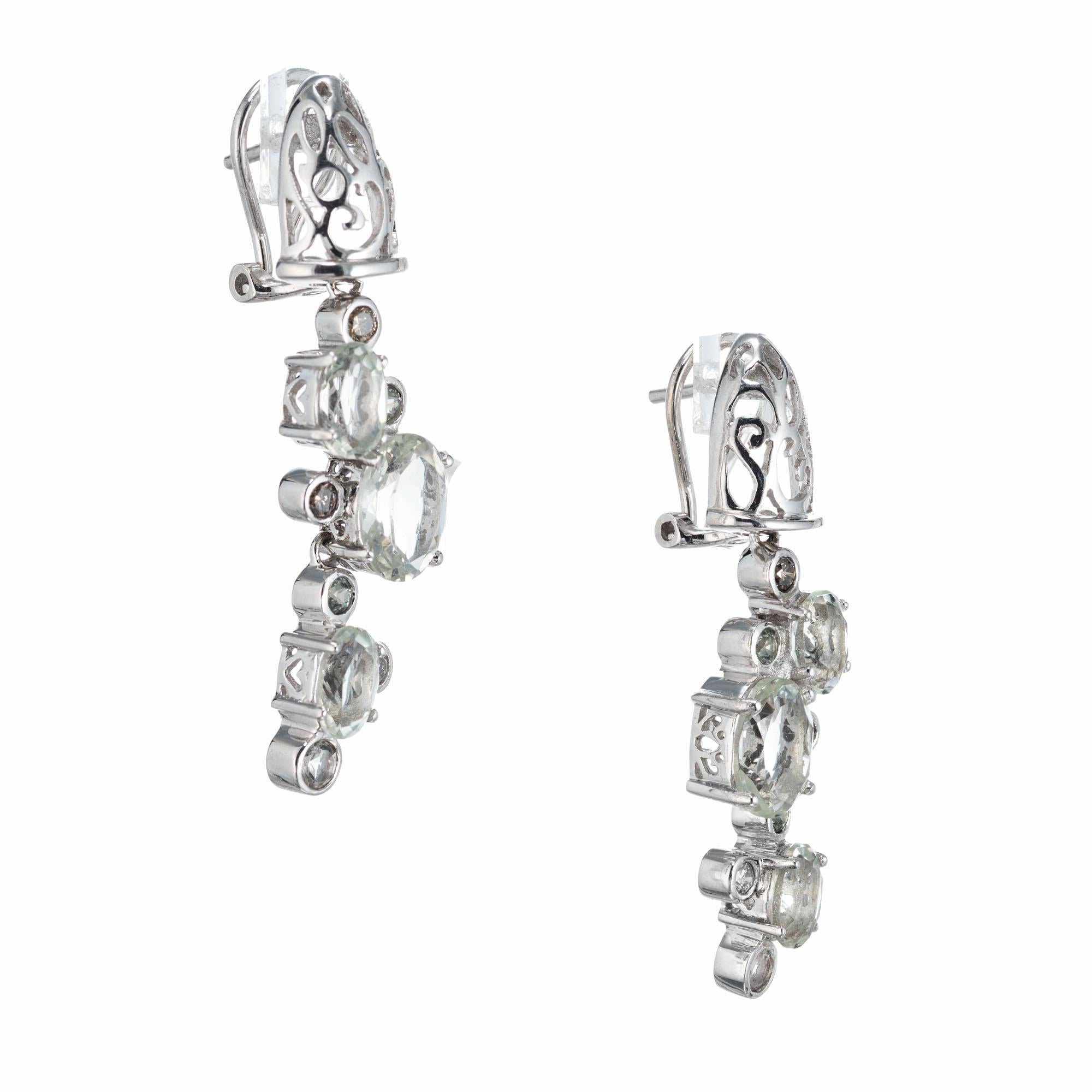 Dangle drop earrings with oval and round aquas, accent with round white and light brown bezel set diamonds set in 14k white gold. Clip post backs.

6 oval light greenish blue aquamarines, approx. 2.90cts
6 round diamonds, K-L SI2 approx. .18cts
6