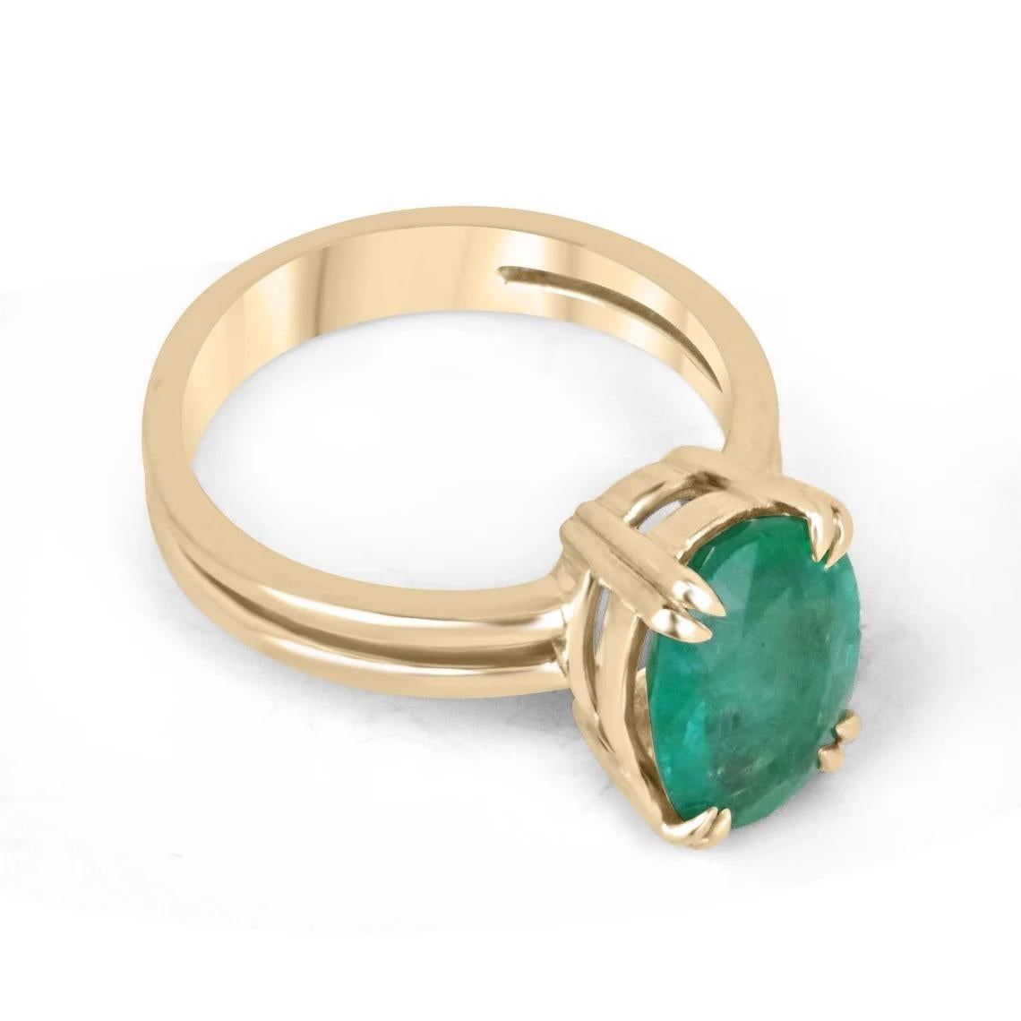 This solitaire ring is a beautiful and elegant piece of jewelry, featuring a 2.90-carat oval cut emerald as its centerpiece. The emerald boasts a rich, lush green color and displays good levels of clarity and luster, making it a truly exceptional