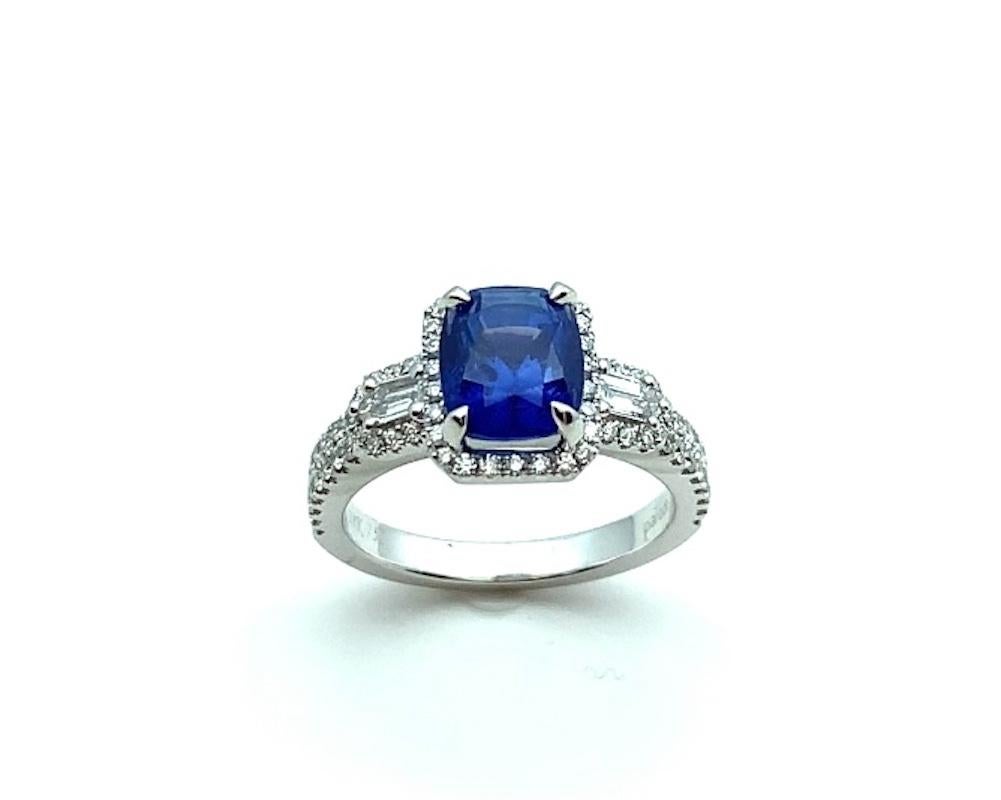This gorgeous cocktail ring features a beautiful blue sapphire cushion set in 18k white gold with baguette and round brilliant cut diamonds! The center gemstone is an ideal shade of cornflower blue with rich, vibrant color and exceptional life.