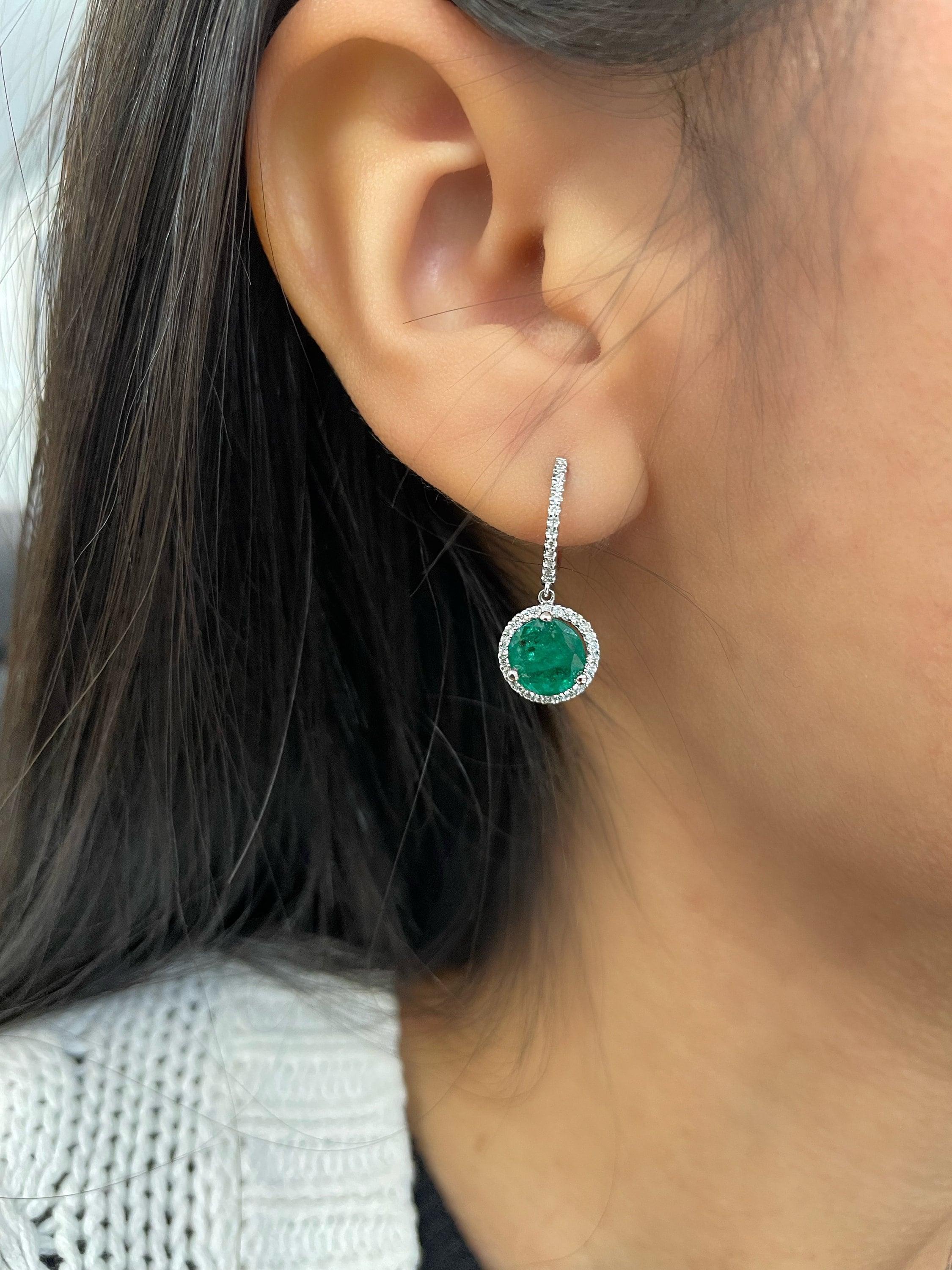 These gorgeous 2.91 ct round emerald & diamond earrings set in 18k white gold are sure to turn heads. Featuring 78 diamonds surrounding the 2 emeralds, they are definitely a great addition to any wardrobe. The diamonds boast a color of F/G and VS1