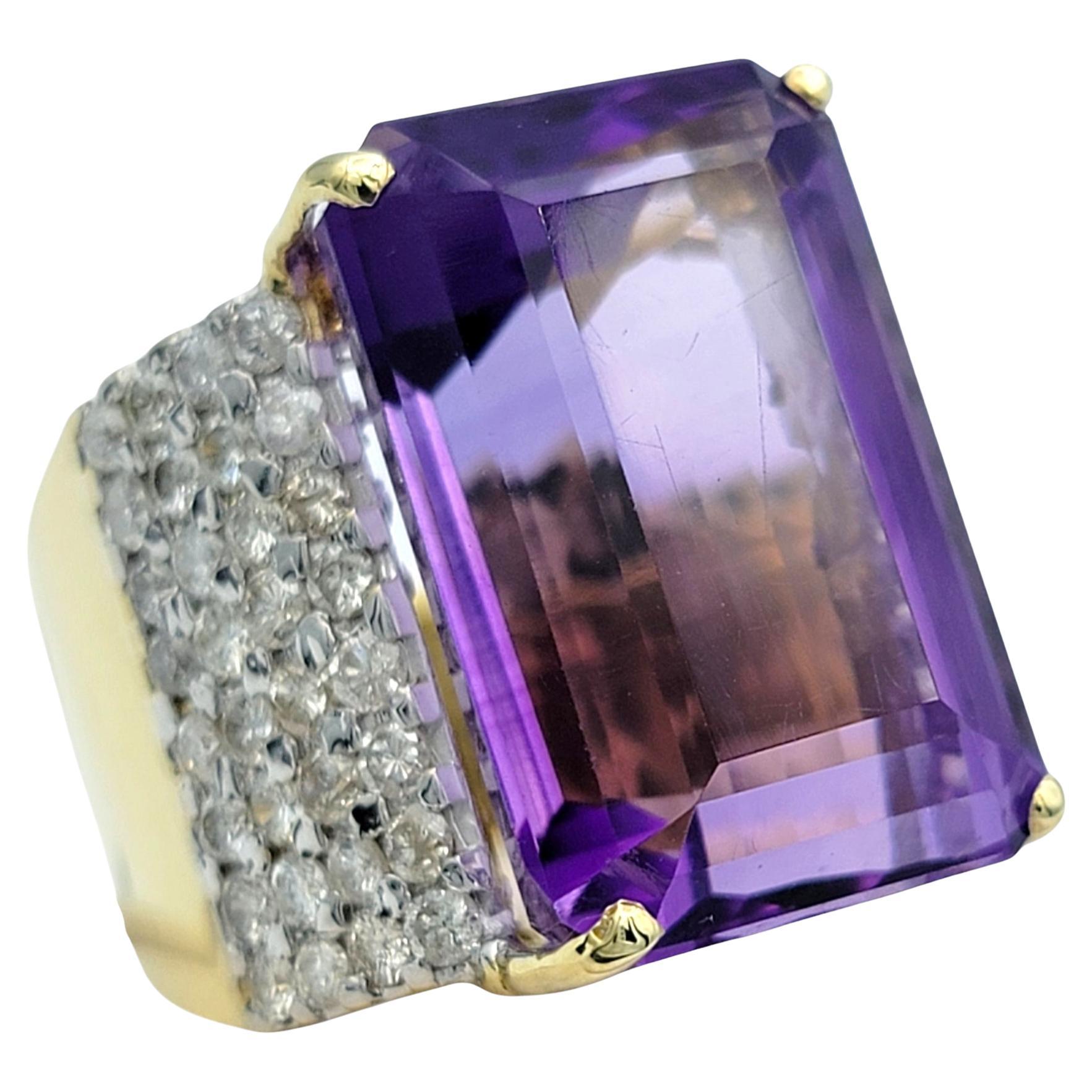 Ring Size: 7 

Unleash a dramatic statement of elegance with this stunning amethyst and diamond cocktail ring. Dominating the design is an exceptional 29.16 carat emerald cut amethyst, its vibrant purple hue exuding regal sophistication and bold