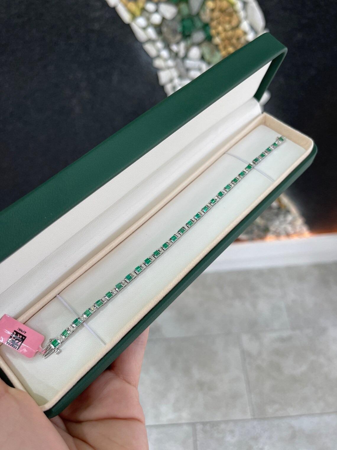 A stunning emerald and diamond bracelet. This sleek piece features over two carats in stunning natural emeralds that showcase a desirable vivid green color and superb qualities. Rows of two brilliant round cut diamonds accent in between each row of