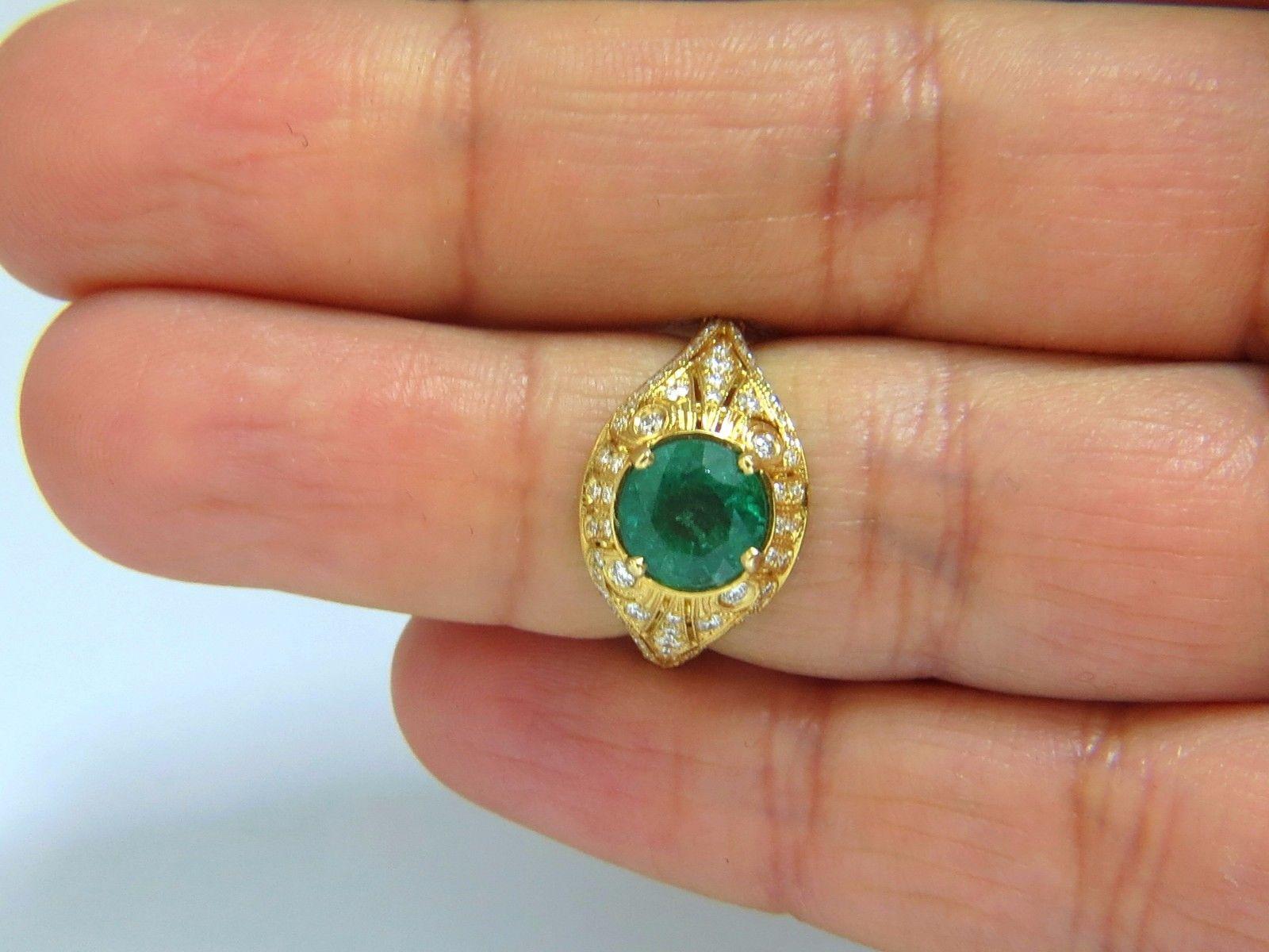 Venetian Mod Deco Green.

1.92ct. Natural Emerald Ring

Round, Brilliant cut

7.7mm Diameter

Transparent & Vivid Green 

1.00ct. Diamonds.

Round & full cuts 

G-color Vs-2 clarity.  

14kt. yellow gold

4.4 grams

Ring Current size: 6.5

Depth of