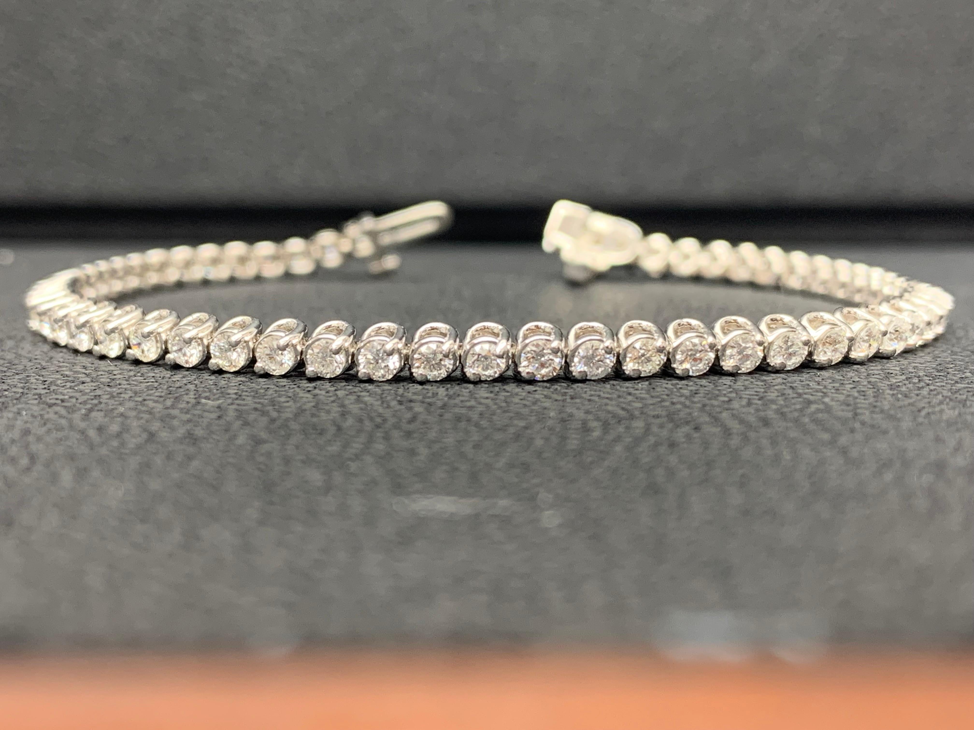 Un bracelet tennis brillant mettant en valeur une rangée de diamants ronds et brillants, sertis dans une monture à lunette en or blanc 14K. Les diamants pèsent 2,92 carats au total.
Tous les diamants sont de couleur GH et de pureté SI1.
Disponible