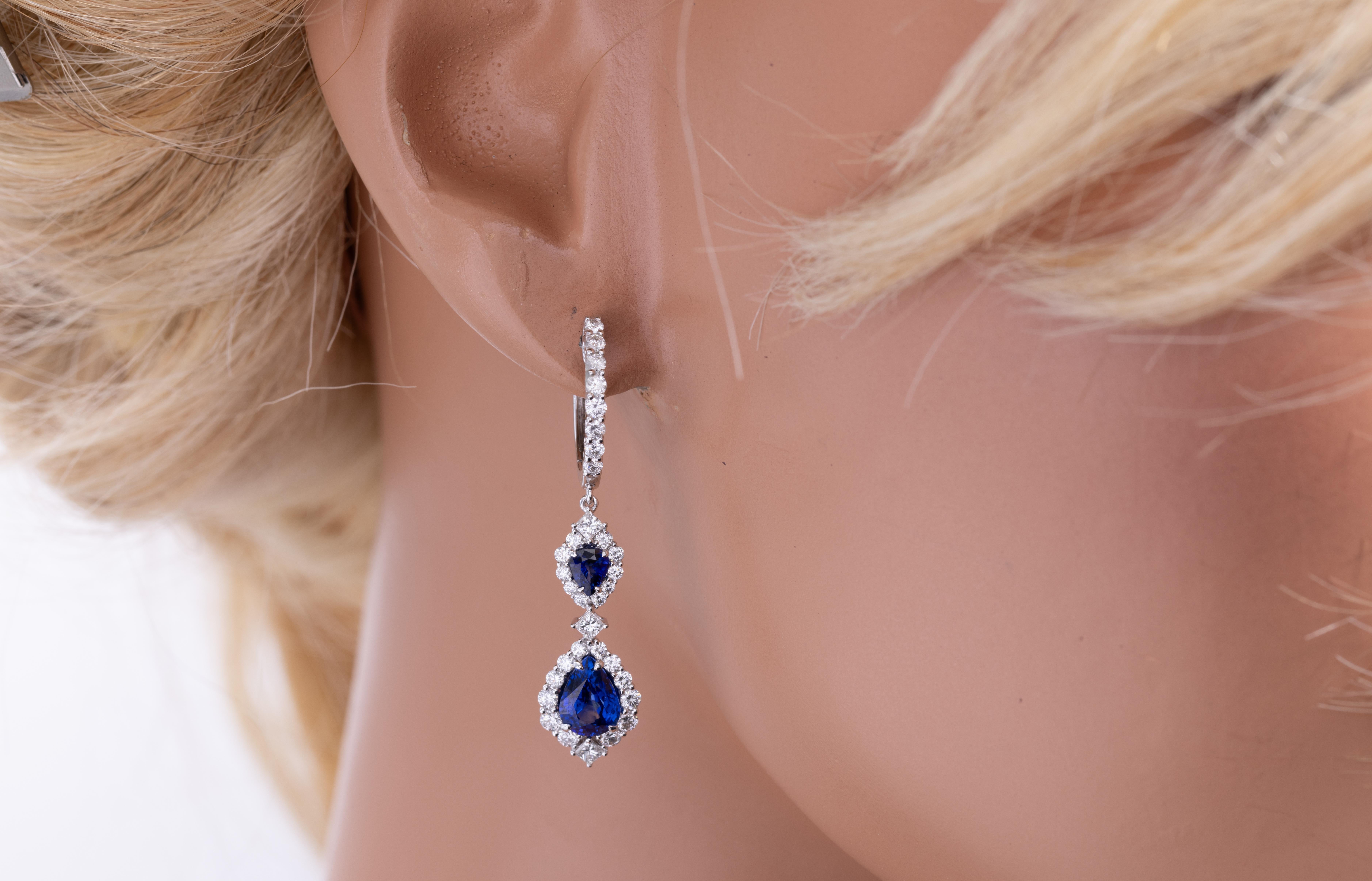 Cattura l'eleganza senza tempo con questi squisiti orecchini a goccia con zaffiro, splendidamente impreziositi da diamanti scintillanti. Ogni orecchino presenta due vibranti zaffiri blu punteggiati da un singolo diamante taglio princess, che