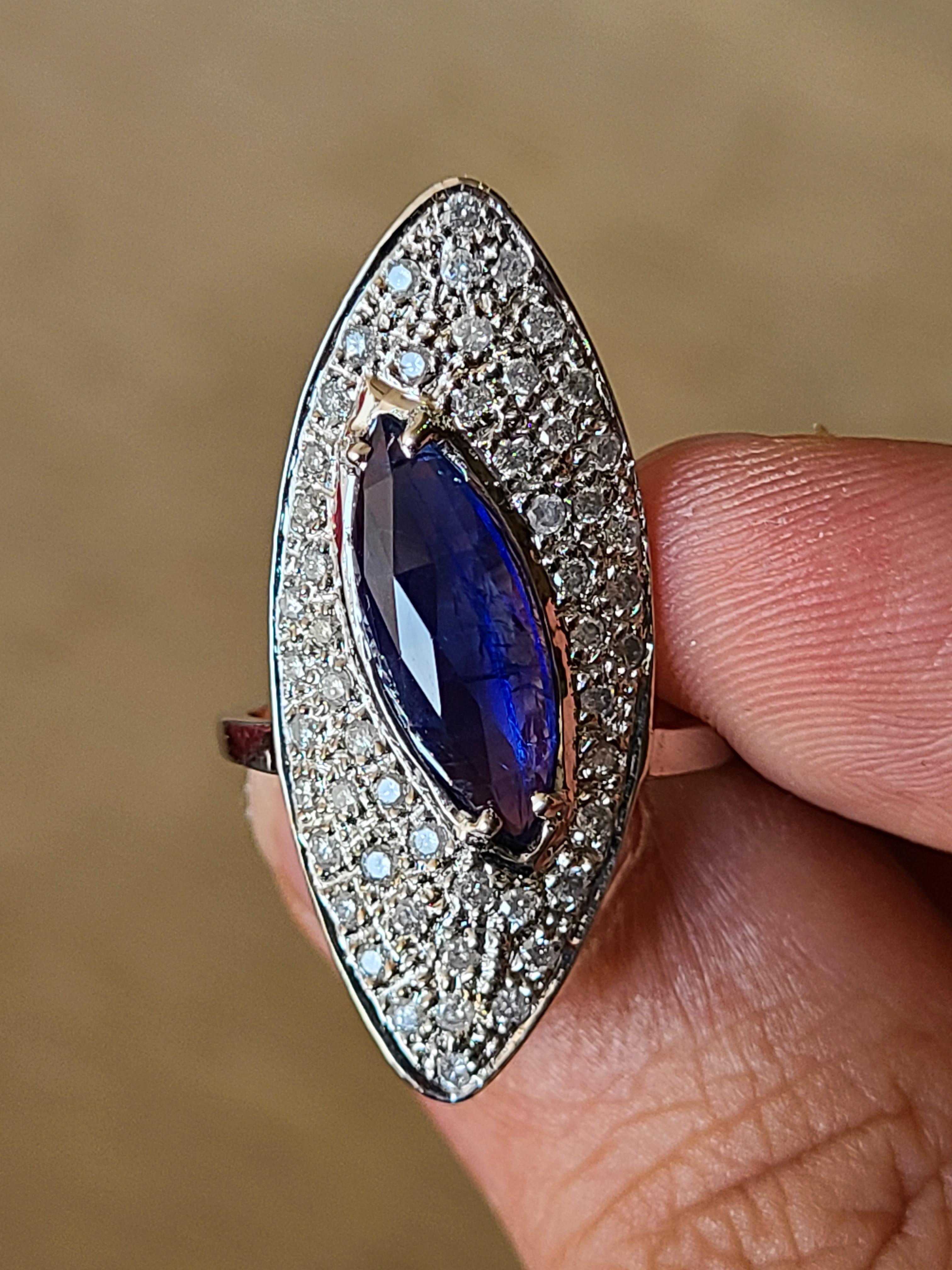 A beautiful and chic blue sapphire marquise cut ring set in 18k gold with diamonds . The blue sapphire originates from Sri-Lanka and weight is 2.92 carats. The diamond weight is .64 carats. The ring dimensions in cm 3.3 x 1.9 x 2.3 (LXWXH). US size