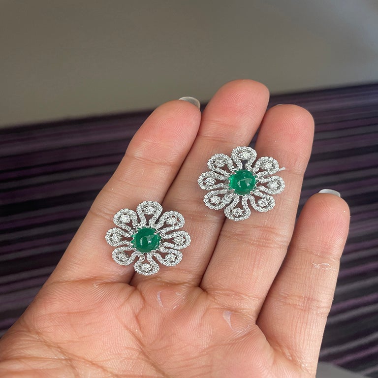 Una combinación de diseño moderno junto a su diseño floral vintage crea un concepto de fusión. Presenta 2 cabujones de esmeralda en su centro, rodeados de diamantes en forma de pétalos, creando un impresionante motivo floral. La esmeralda de 2,92