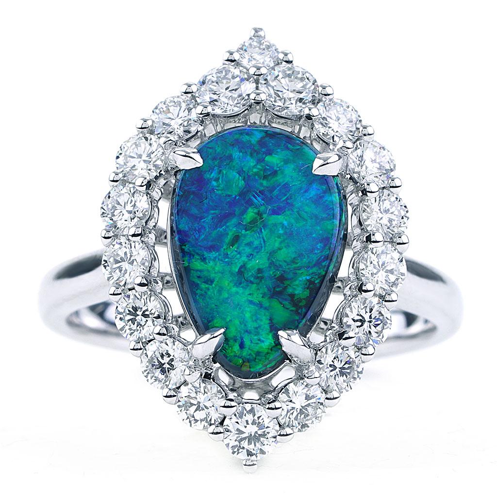 This fashion ring is made of 18k white gold and weighs approx. 6.5 grams. The center stone is an Australian black opal weighing 1.86 carats. It is adorned by a marquise shaped halo containing 18 round diamonds G color, VS clarity weighing a total of