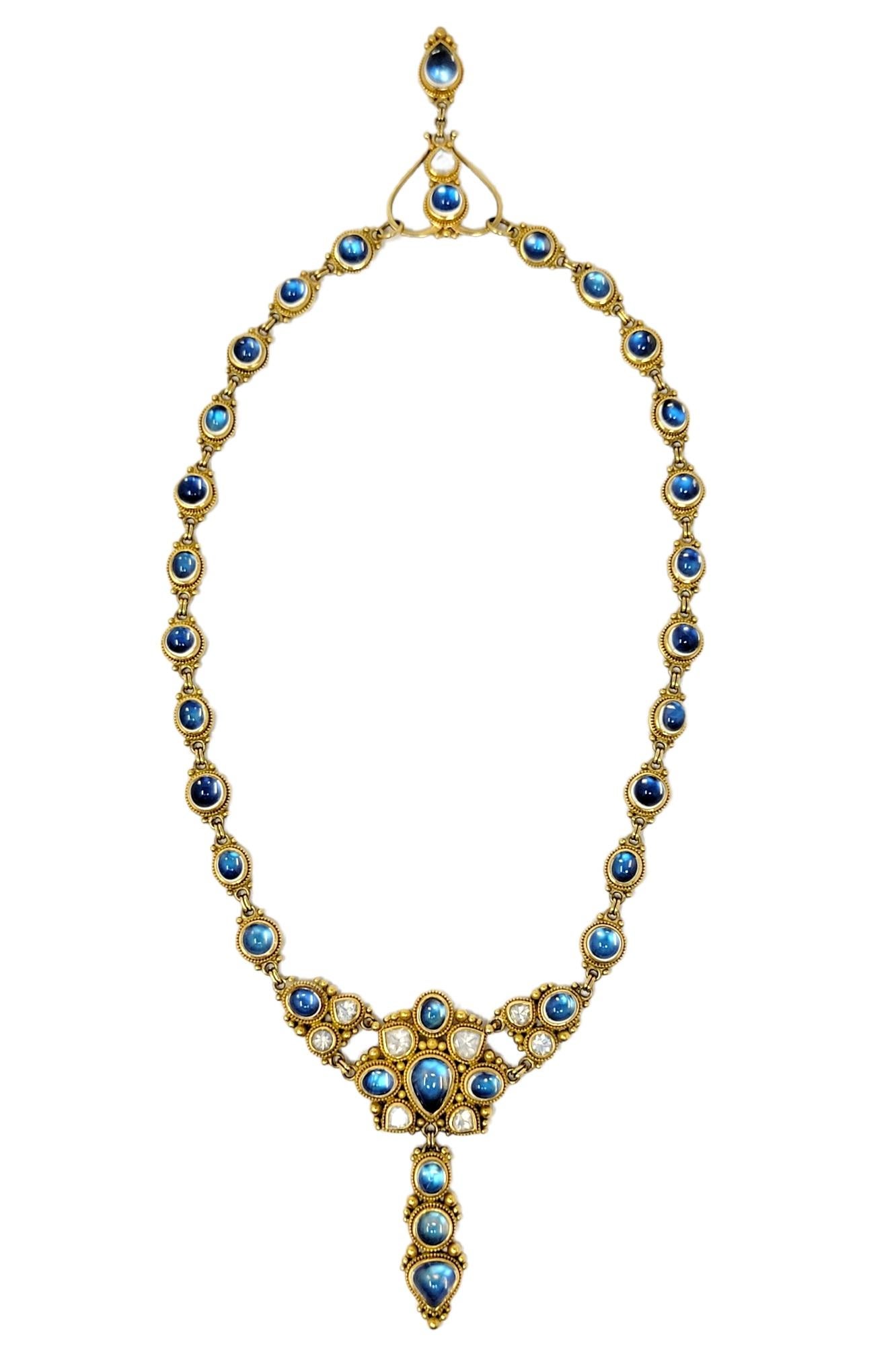 Incredible 21 karat gold and moonstone drop necklace absolutely radiates on the neck. The unique piece is filled with glowing iridescent cabochon stones throughout, giving a magical and luxurious feel. It features rounded bezel set moonstones set in