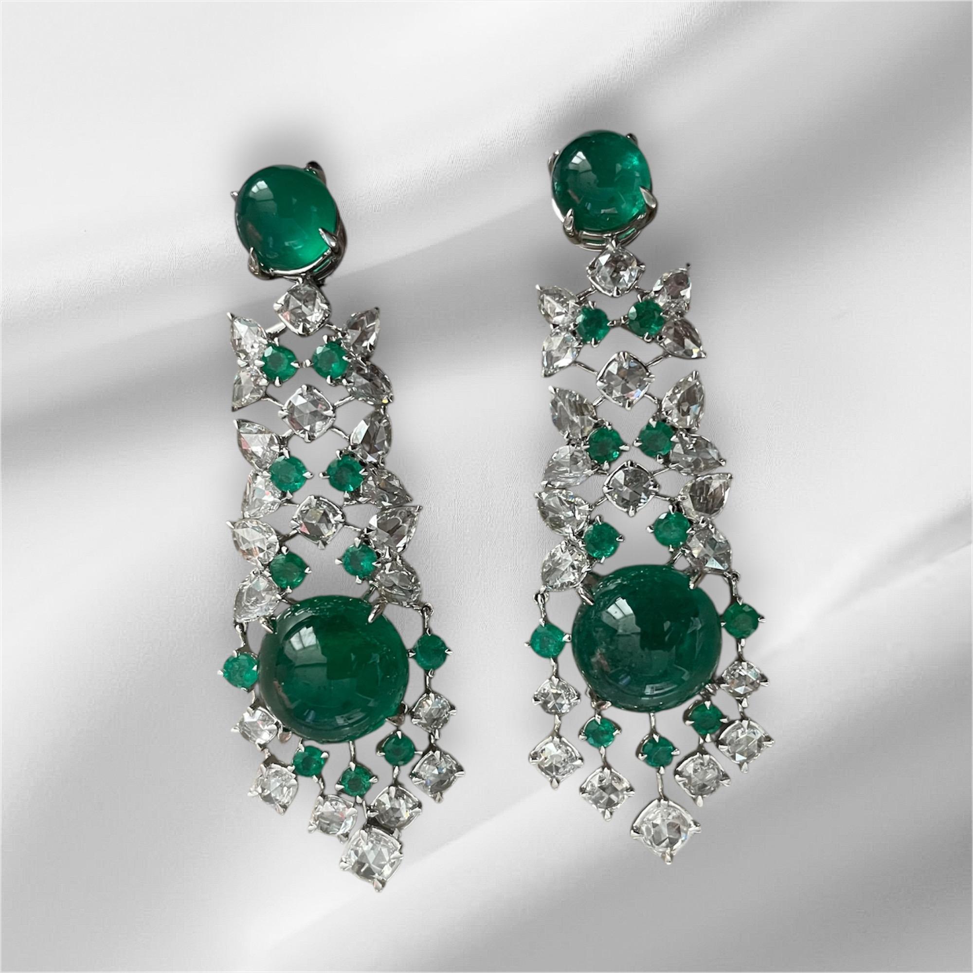 Dieses auffällige Paar sambischer Cabochon-Smaragd- und Diamant-Ohrringe ist ein wahres Meisterwerk, das den lebendigen Charme sambischer Smaragde mit der zeitlosen Eleganz von Diamanten verbindet. Oben wird ein glatter, runder Cabochon-Smaragd von