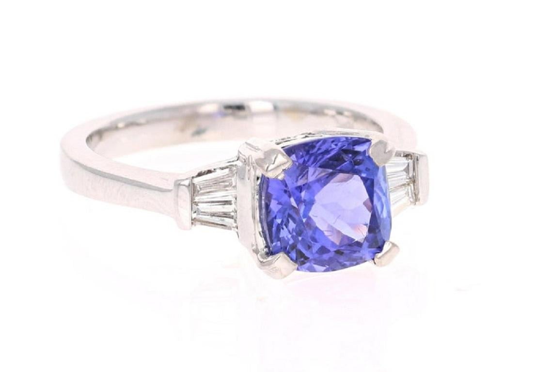 This ring has a gorgeous Cushion Cut Tanzanite weighing 2.69 Carats. The 4 baguettes on the side which weigh 0.21 Carats totally compliment the depth and uniform purple color of the Tanzanite, giving this ring the characteristics of a unique and