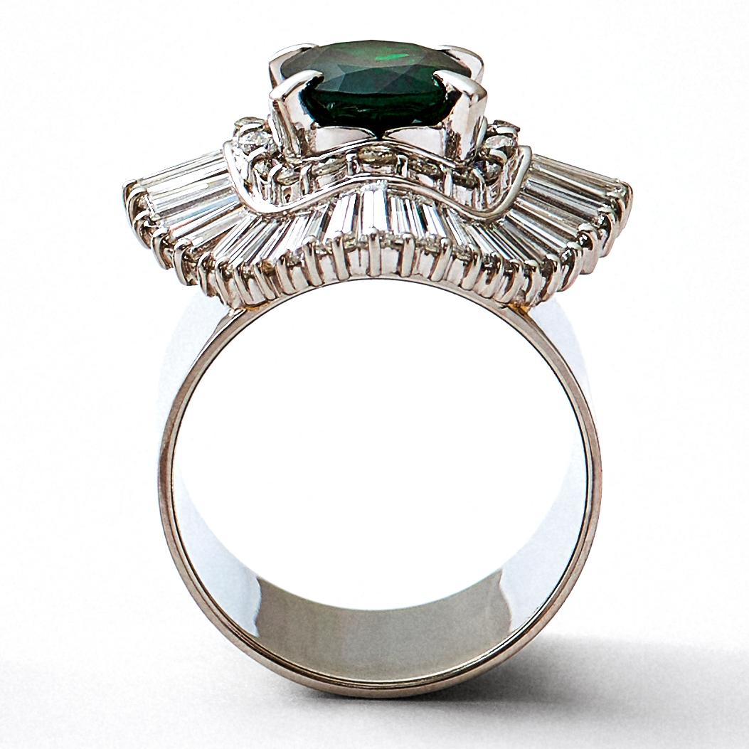 This is a luxurious, one-of-a-kind platinum cocktail ring that combines a repurposed vintage high jewelry stone setting with a wide ring band. This rare and classic setting was made by highly skilled craftsmen and features an oval cut green garnet