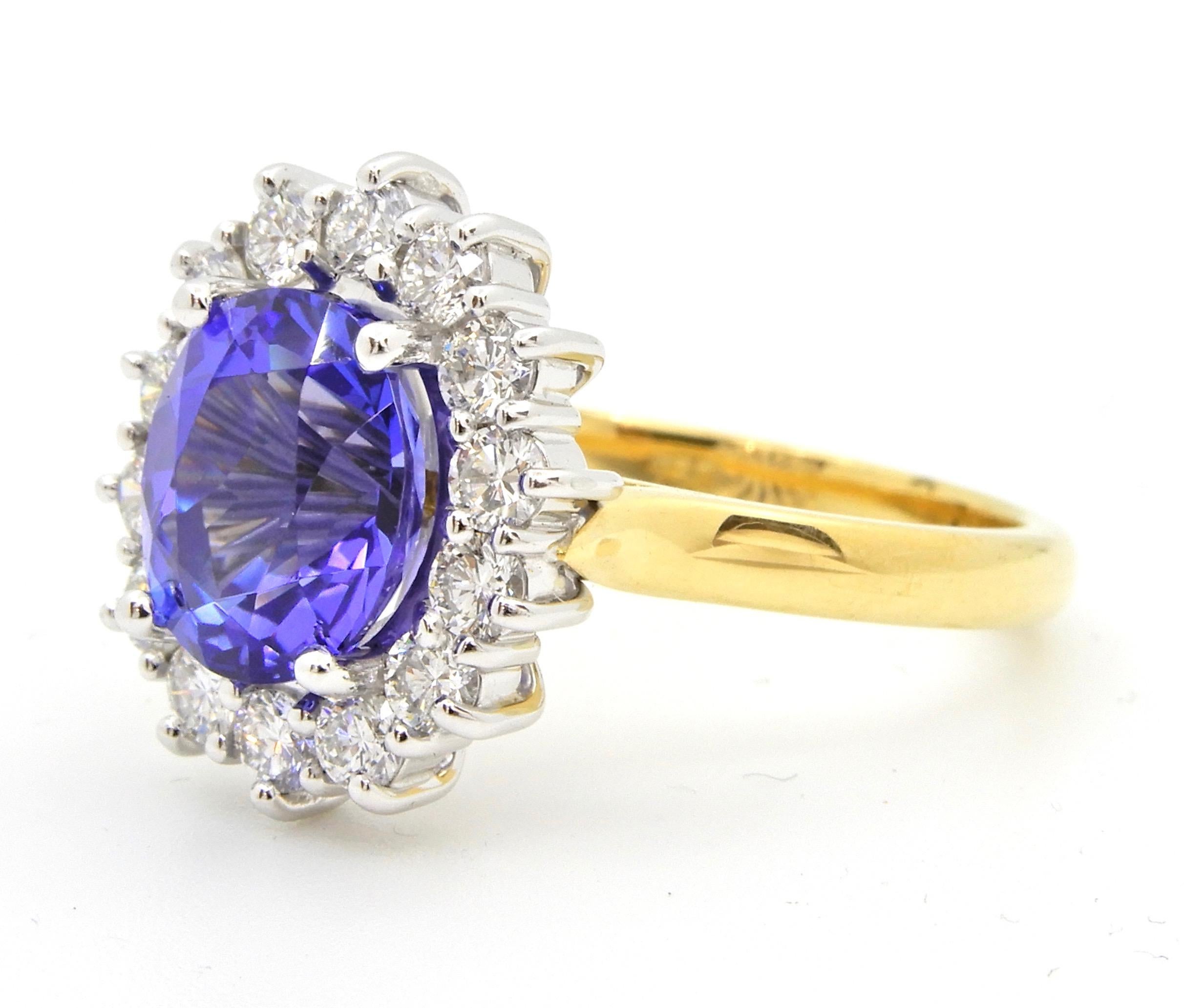 This 2.93 Carat Oval Cut Tanzanite and Diamond Handmade 18 Carat Cocktail Ring is set in 18 carat gold. The slightly rounded, flat edge, yellow gold band rises to a white gold 4 claw set oval Tanzanite of a beautiful, bright blue colour surrounded