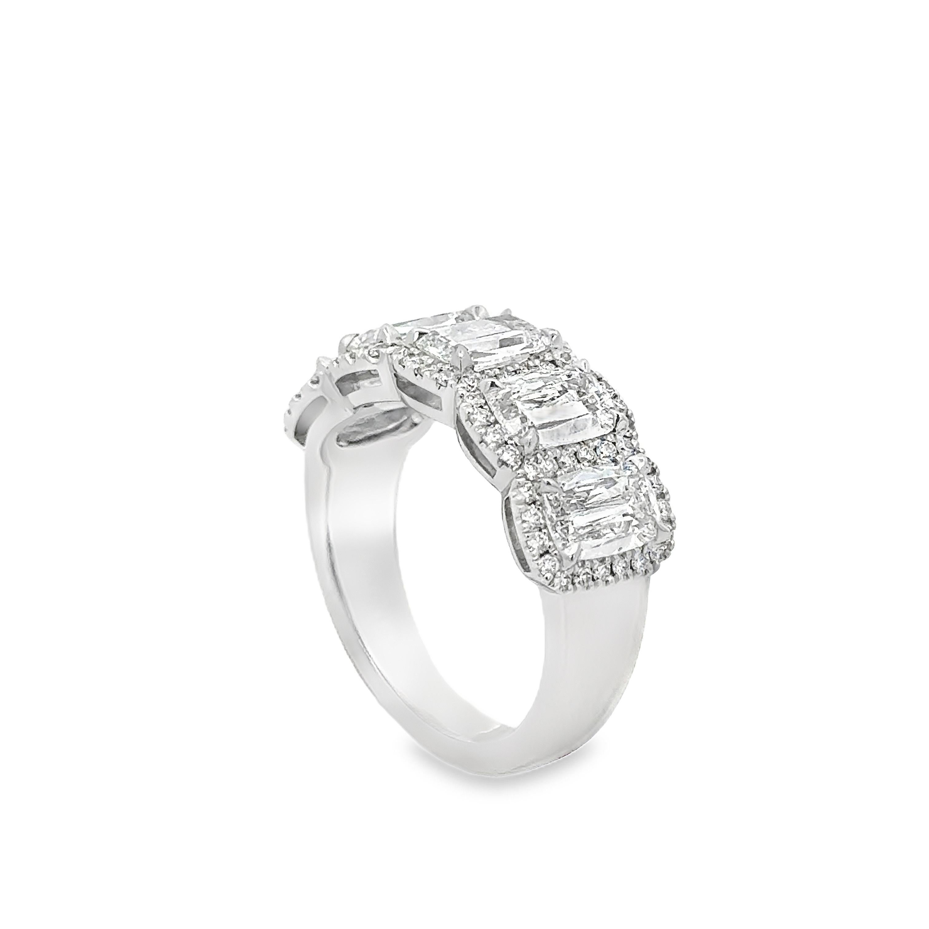 A stunning five stone band, featuring elongated brilliant cushion cut diamonds weighing 2.57 carats total with D-F color and VS+ clarity, each set on a four claw prong setting. Accented by a shared halo of round cut diamonds weighing 0.36 carat
