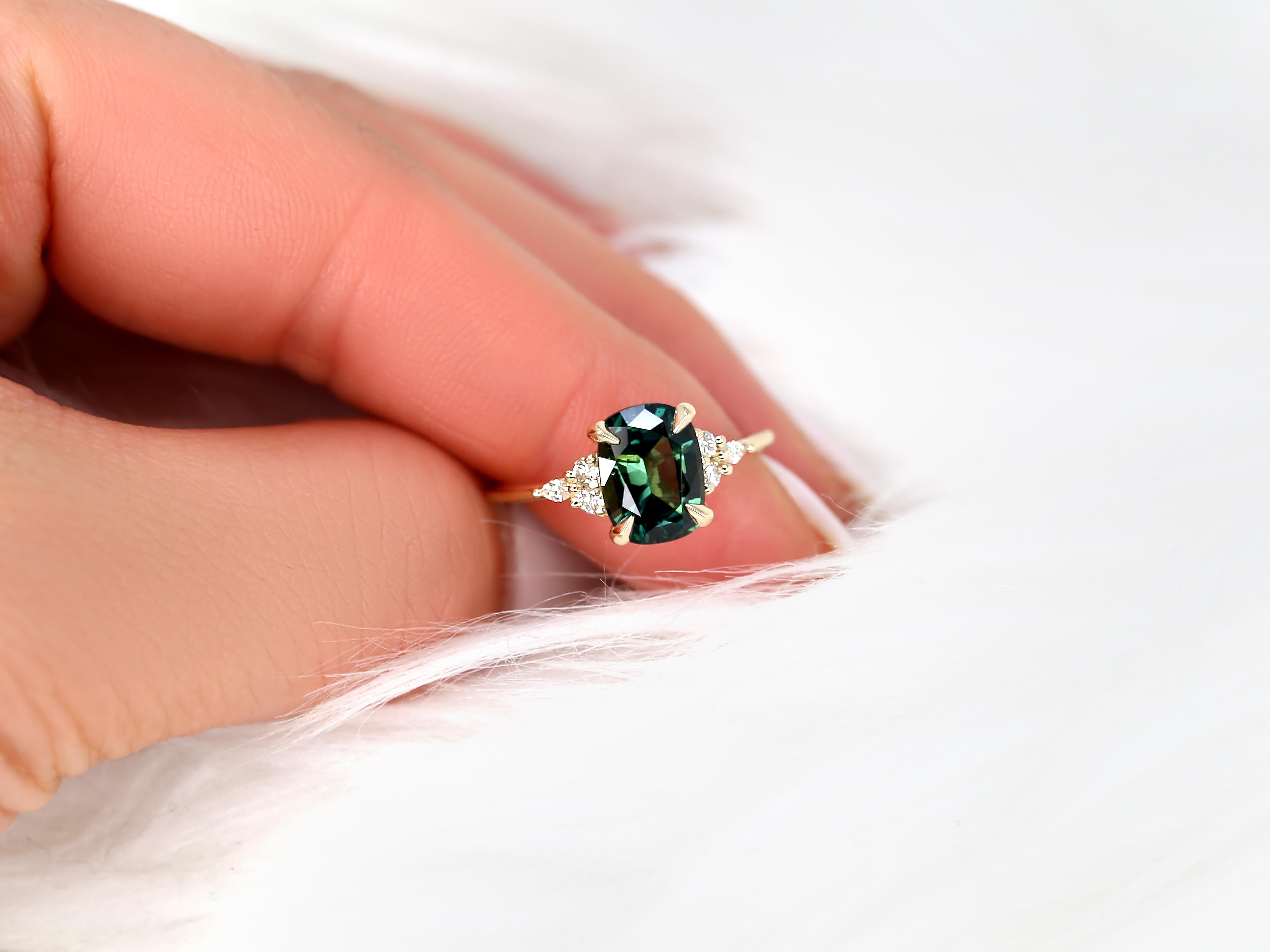 Indulge in the splendor of our breathtaking teal cushion sapphire cluster ring. Designed for those who seek a touch of the extraordinary, this handcrafted piece is as unique as it is gorgeous, a true testament to sophisticated elegance.

Details of