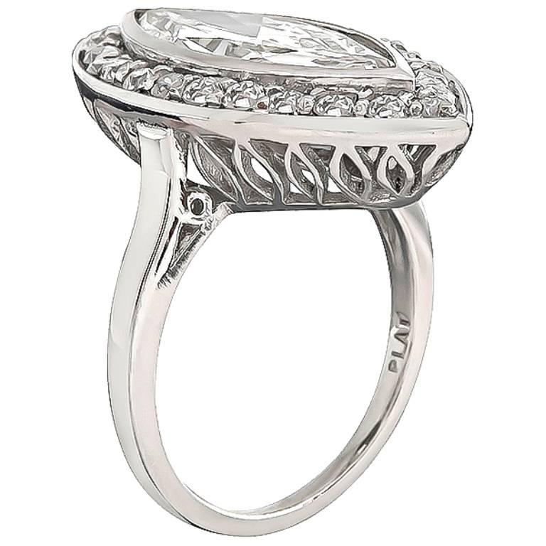 This unique platinum engagement ring inspired from the Art Deco era, is centered with a sparkling marquise cut diamond that weighs 2.95ct. graded H color with SI1 clarity. The center diamond is accentuated by dazzling old mine cut diamonds that