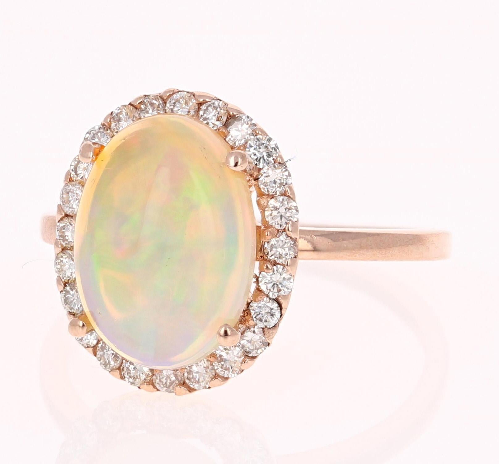 Opulent 2.95 Carat Opal and Diamond Ring in 14K Rose Gold.
The beautiful Opal with its striking flashes of color weighs 2.55 carats. It is surrounded by 24 Round Cut Diamonds that weigh 0.40 carats (Clarity: VS2, Color: H).  This 14K Rose Gold ring