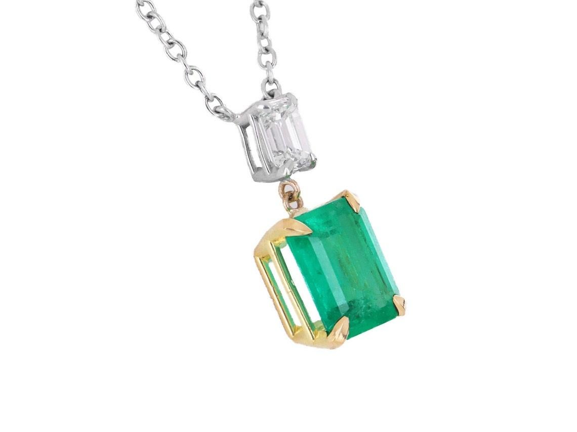 Take a look at this stunning Colombian emerald and diamond necklace. The natural, Colombian emerald carries a full 2.46-carats, of vivid green color, with a yellowish hue. The stone displays excellent luster and eye clarity. Accented at the top, is