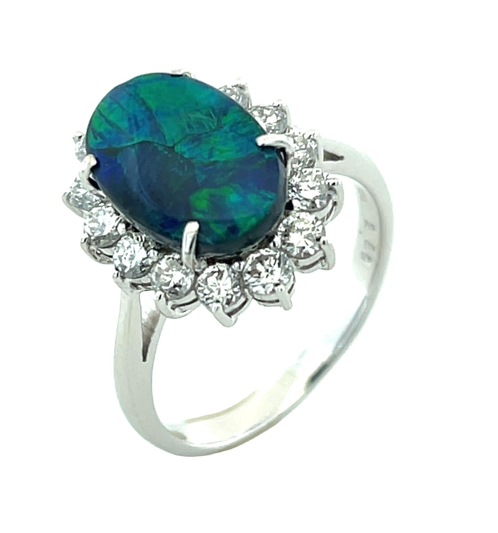 This stunning black opal and diamond cocktail ring features a gorgeous 2.96 carat black opal with vibrant play-of-color surrounded by a halo of white diamonds! The black opal is a phenomenally fine gemstone, displaying large, primarily neon green