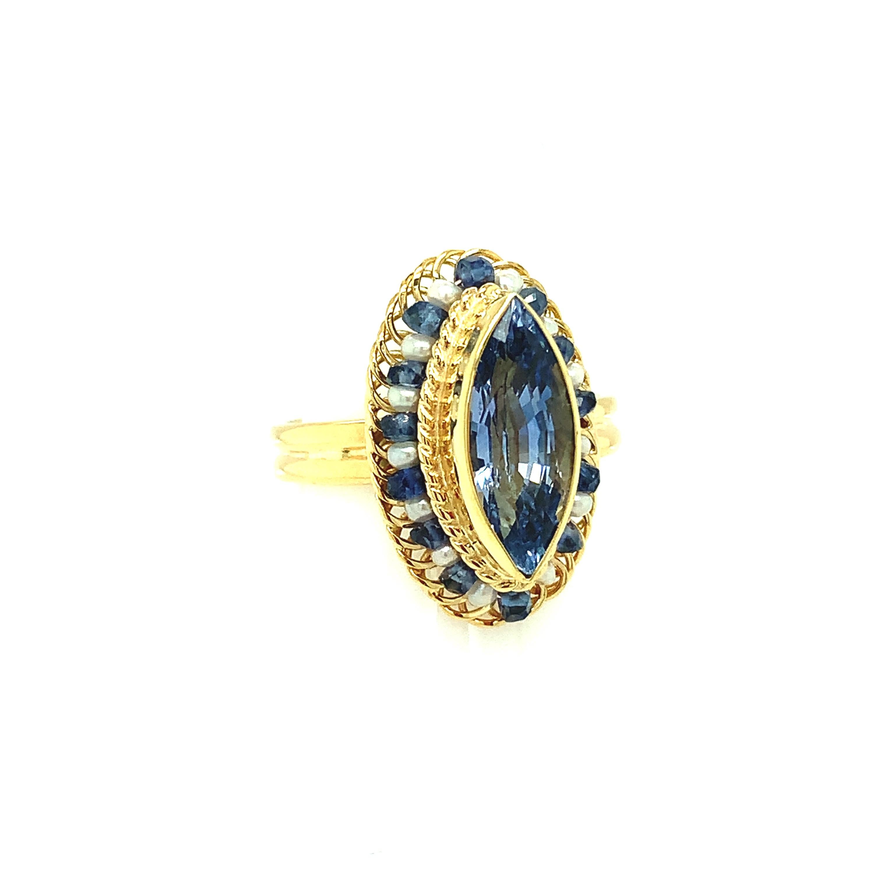This beautifully handmade sapphire ring is one-of-a-kind! The rich blue, marquise-shaped sapphire is bordered by seed pearls and sapphire beads that have been delicately strung on 18k yellow gold wire. This design showcases the intricate form of