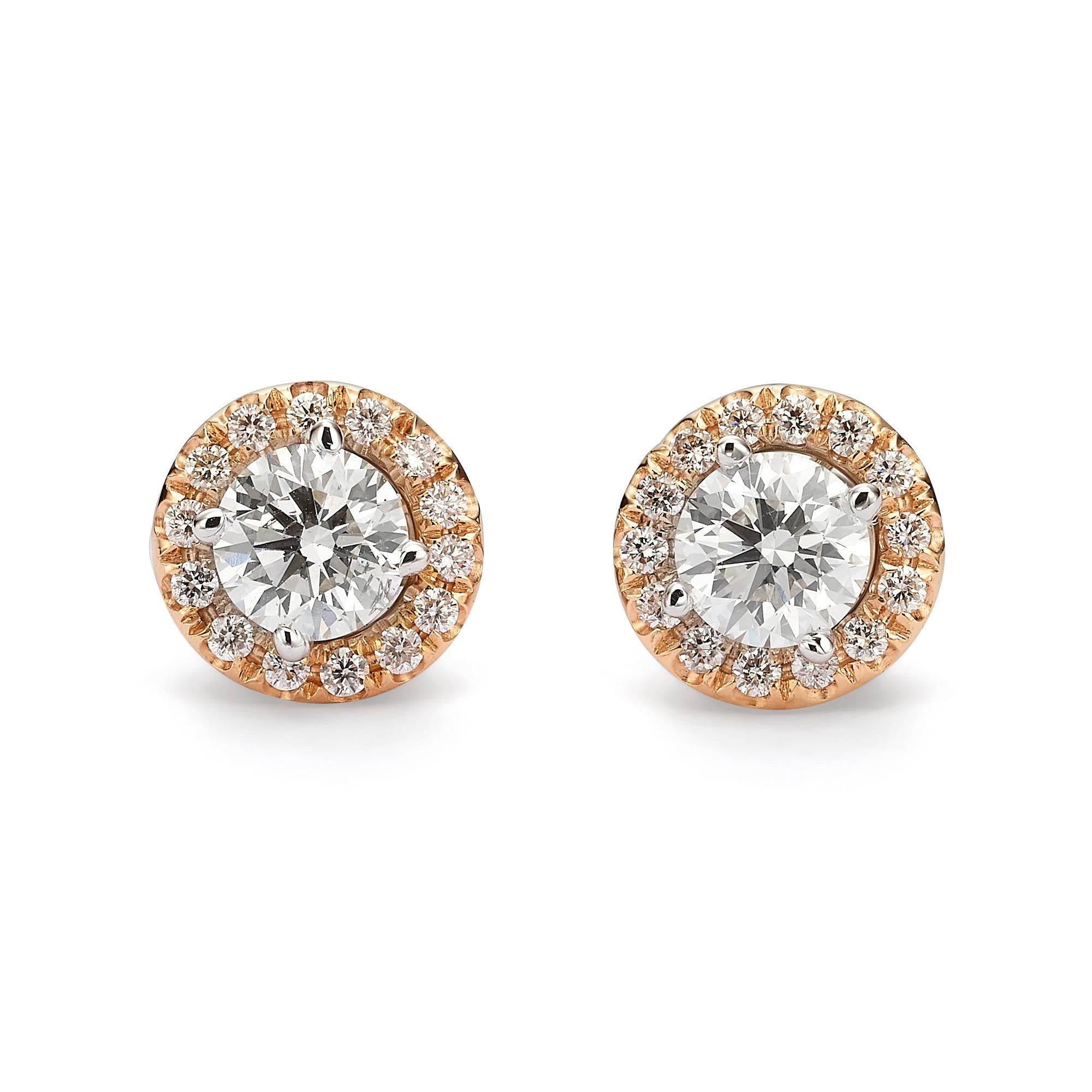 An assembling 18k white a rose gold halo earrings.other in 18K rose gold. Each earring has a center stone of  1.01 carats (combined total weight of 2.02 carats) H-I SI2-I1. The center stones are encircled by a loose rose gold jacket, adorned with