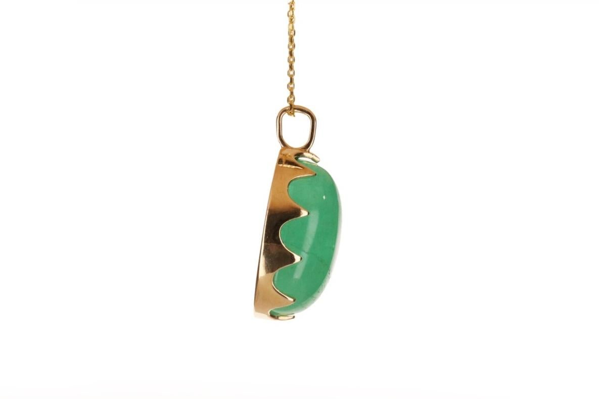 Featured here is a stunning, cabochon oval Colombian emerald pendant in fine 14K yellow gold. Displayed is a medium-green emerald prong-set in a prong setting. The earth mined, green Colombian emerald has an incredible green color with clean clarity
