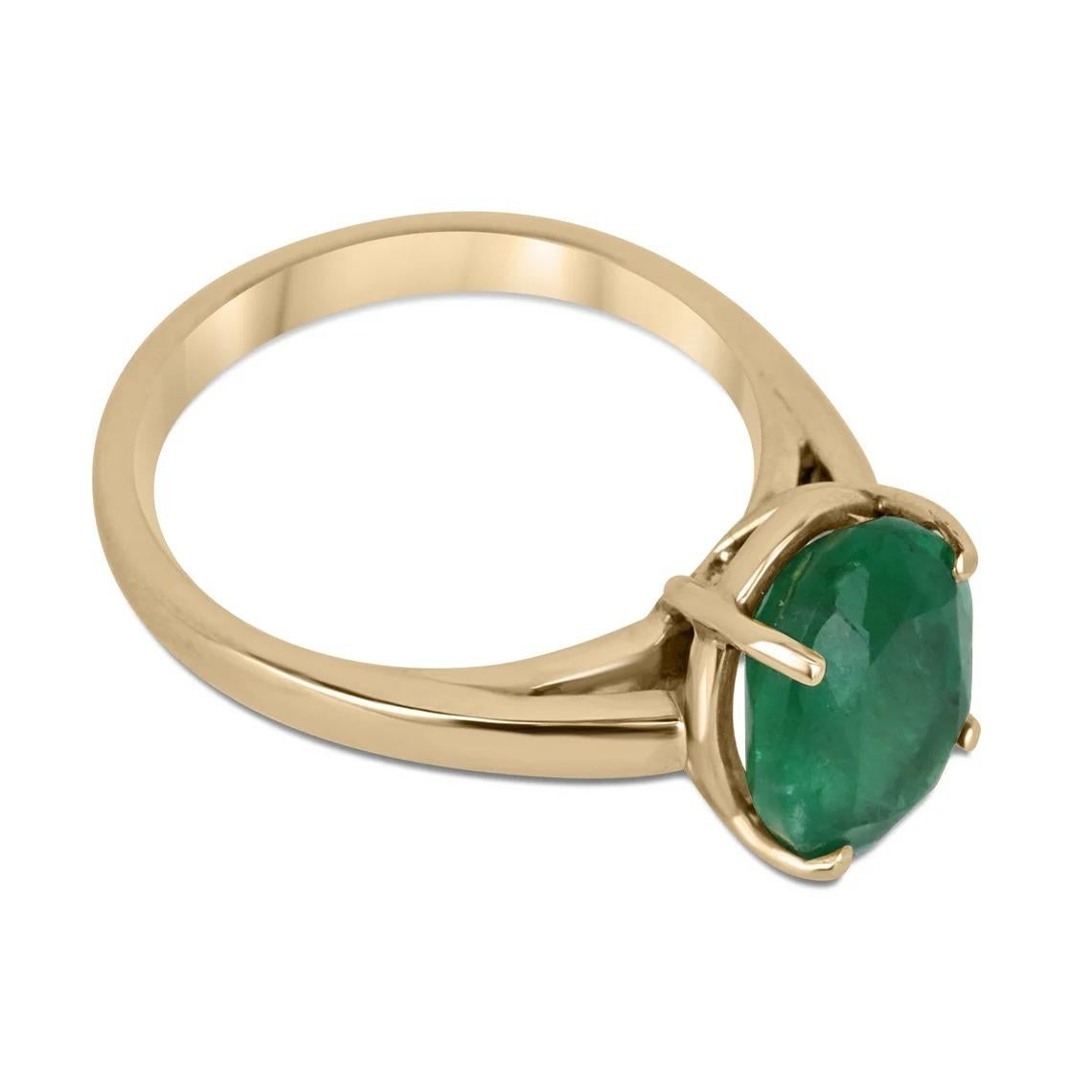 This stunning emerald solitaire ring features a 2.98 carat oval cut emerald with a rich, dark forest green color that is sure to catch the eye. The emerald is set in a classic four-prong setting, which allows for maximum light to enter and enhance