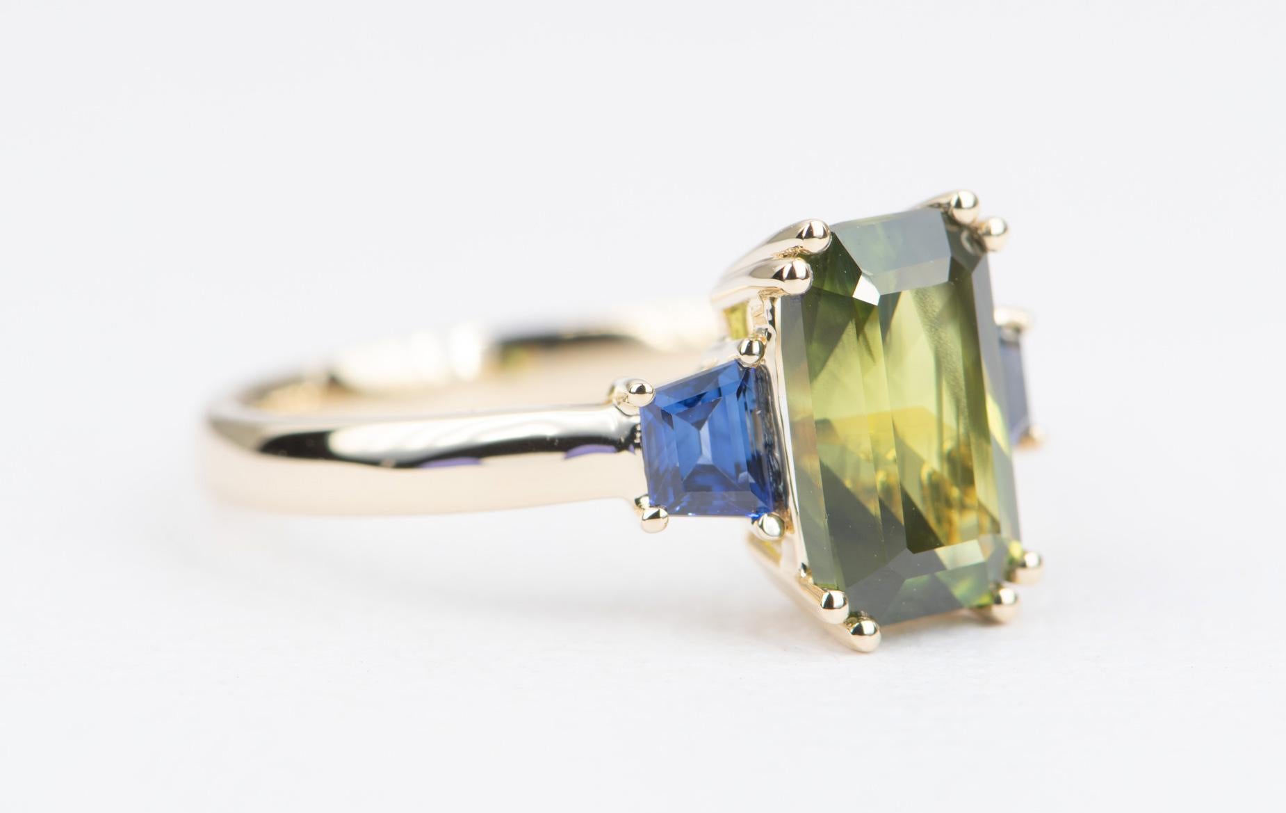 ♥  Solid 14K yellow gold ring with an emerald-shaped green sapphire in the center, flanked by blue sapphire on the sides

♥  Material: 14K yellow gold
♥  US Size: 7 (Free resizing)
♥  Band width: 2.7mm
♥  Gemstone: Center sapphire is 2.98ct; side