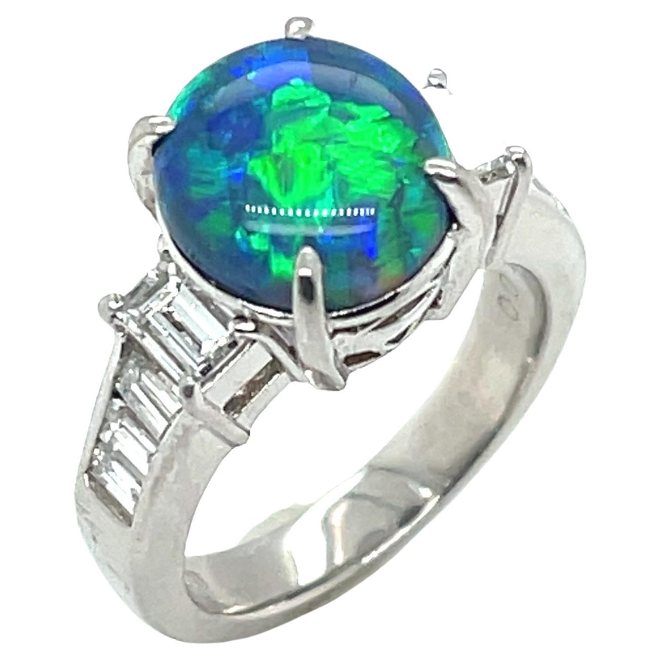 This beautiful platinum ring features a 2.99 carat fine black opal set with sparkling baguette diamonds! The black opal has gorgeous play-of-color including flashes of bright green, turquoise blue and and peacock violet. A large baguette-cut diamond