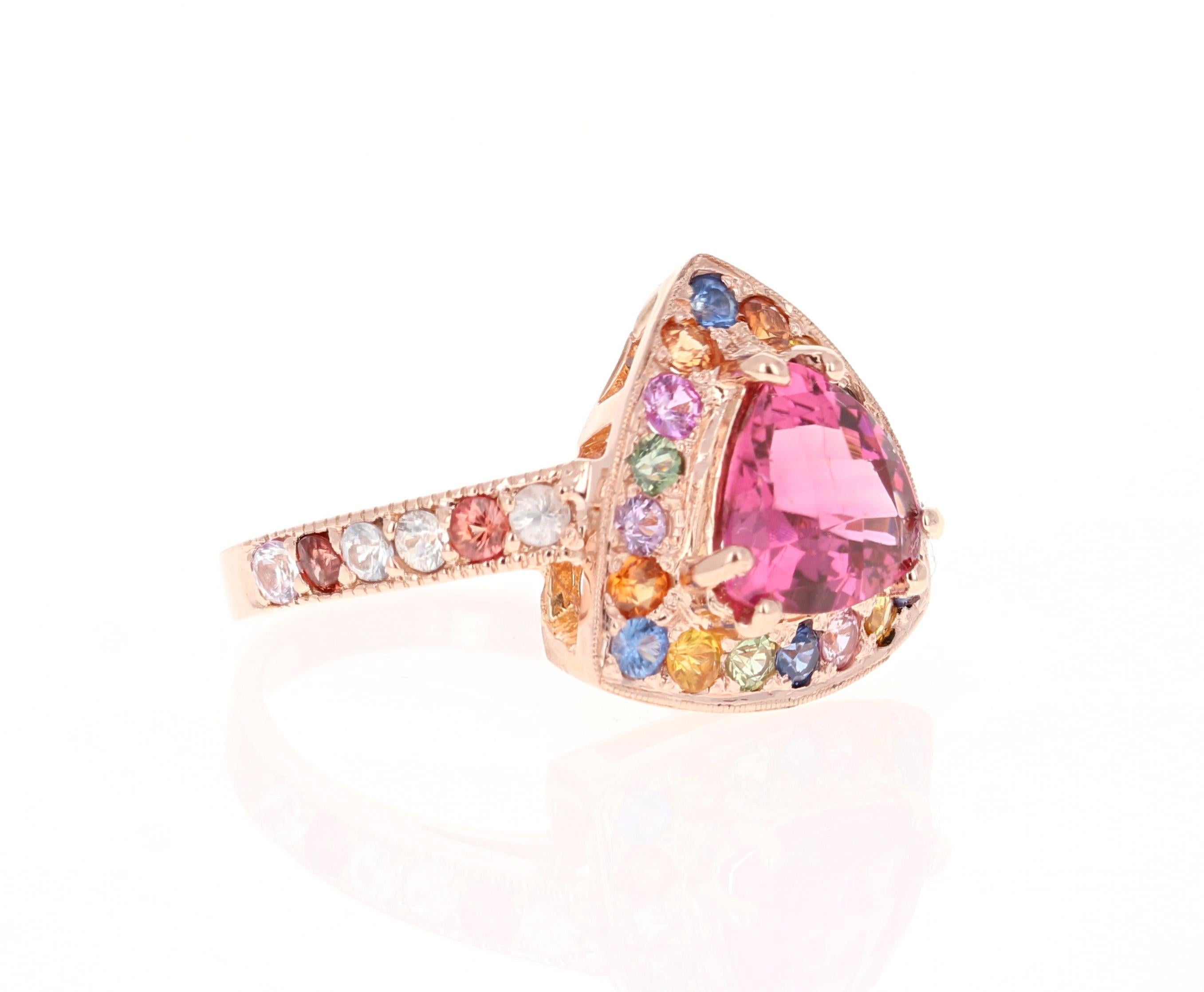 This ring has a Trillion Cut Tourmaline that weighs 1.62 carats and is surrounded by 30 Multi Sapphires that weigh 1.37 carats. The total carat weight of this ring is 2.99 carats. 

This ring is casted in 14K Rose Gold and weighs approximately 5.0