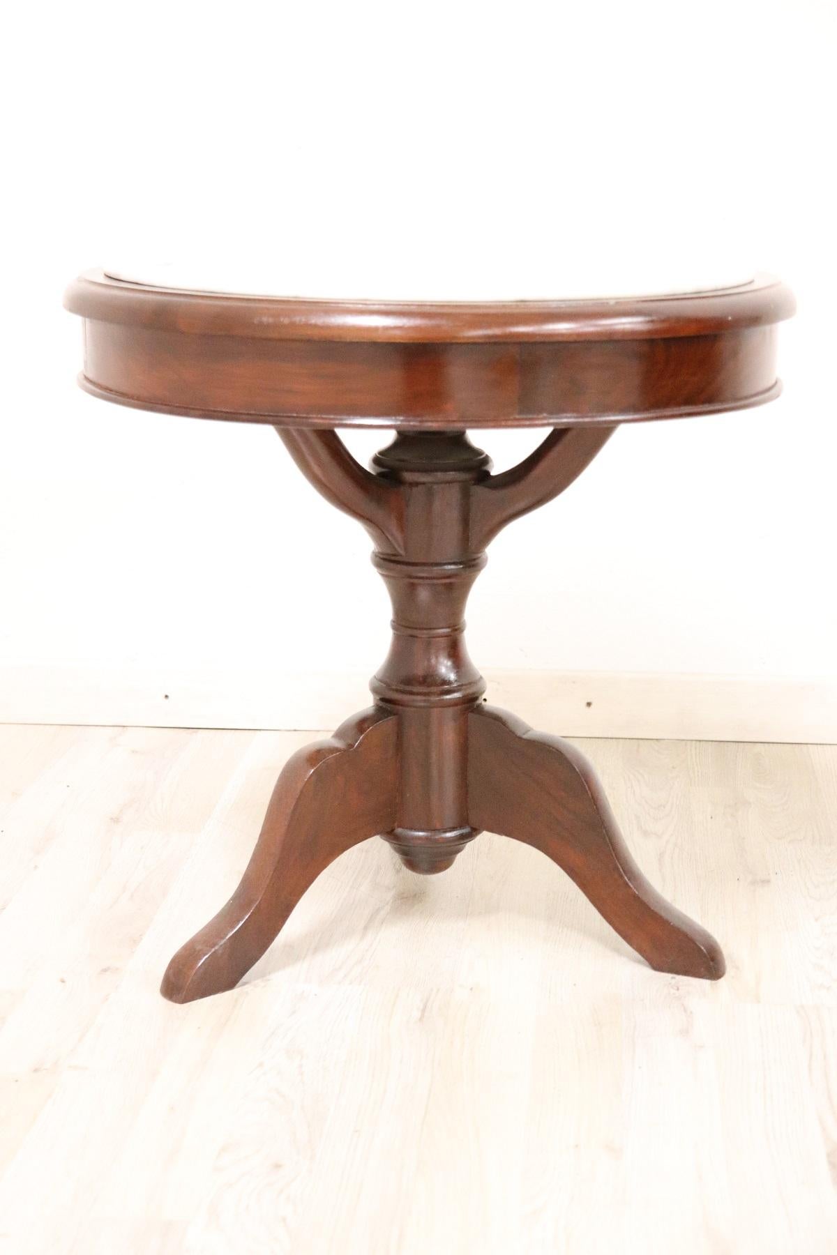 Rare and fine quality Italian 1880s round sofa table or coffee table. The table in precious mahogany wood with finely turned central pedestal. The support surface is in Italian white Carrara marble. Perfect condition ready to be placed in your