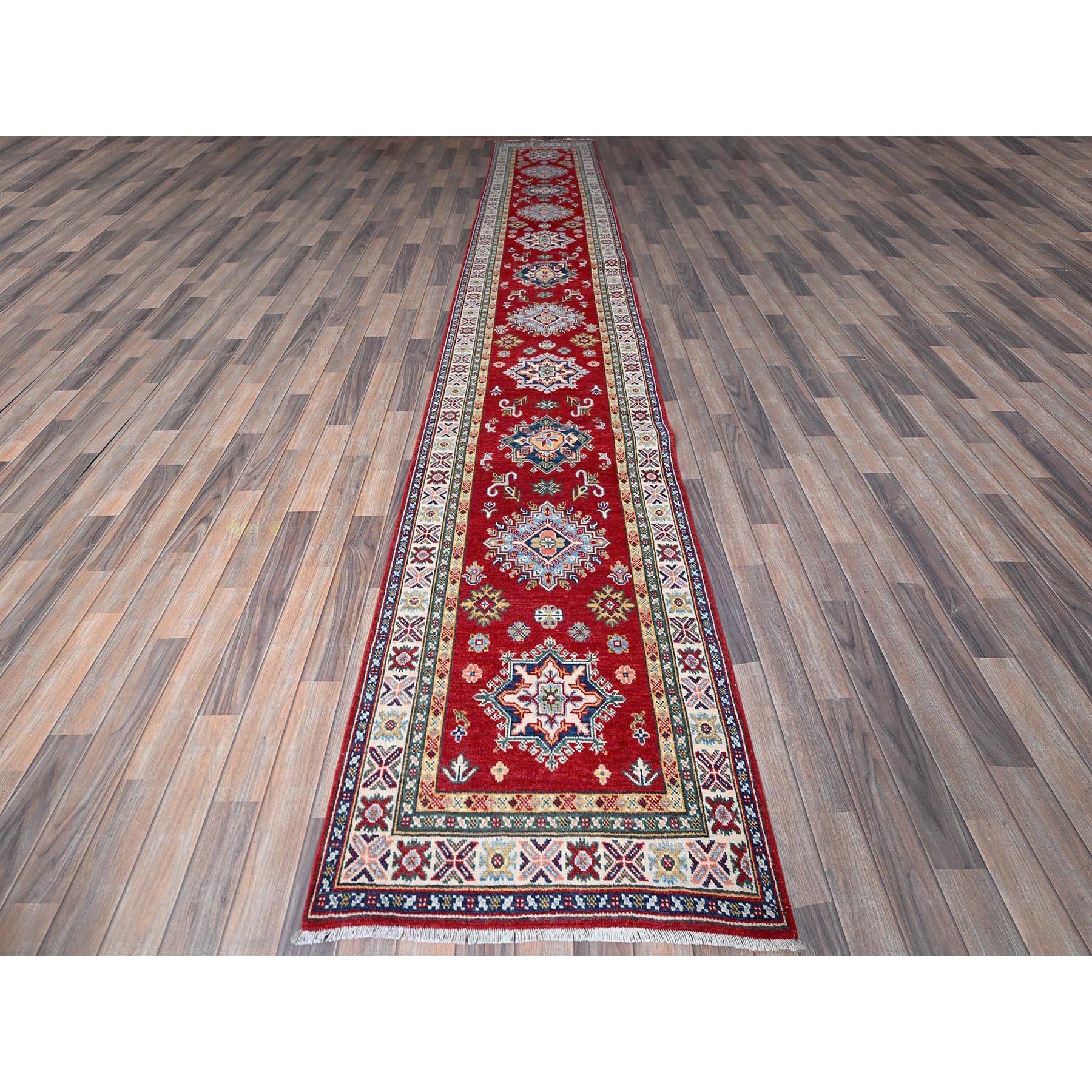 Chili Rot, Kazak mit Tribal Medaillons Design, weiche und glänzende Wolle, Pflanzenfarben, handgeknüpft, dichtere Webart, XL Läufer, Orientteppich
Primäre MATERIALIEN: Wolle
Latex: Kein Flor 
Höhe: 0,25 Zoll
Stil: Traditionell
Grundfarbe: