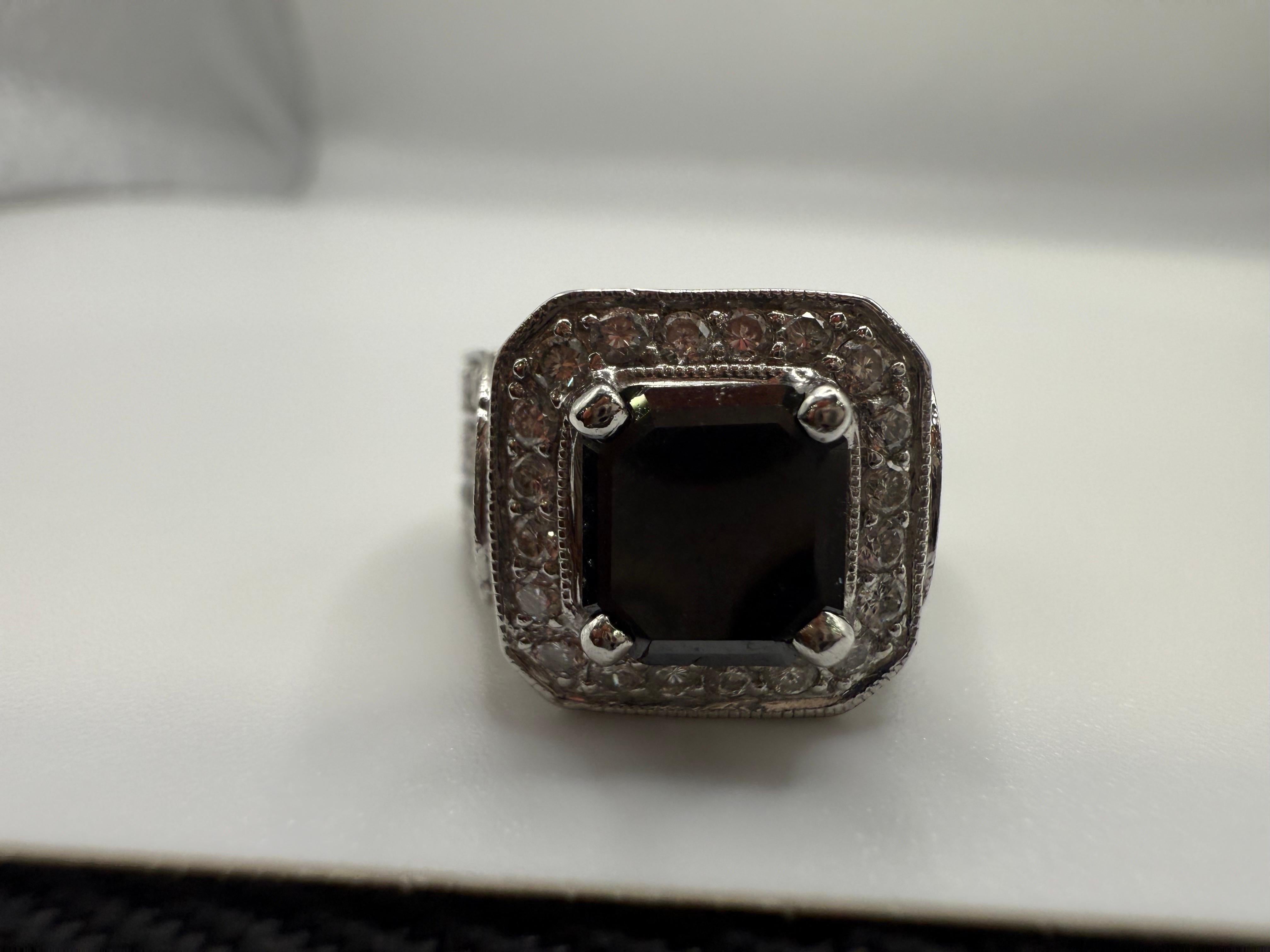 Uno splendido diamante nero naturale al centro, del peso di 2 carati, accompagnato da 1 carato di diamanti bianchi che creano un bellissimo contrasto su questo anello con sigillo da cocktail realizzato in oro 18KT.

**Tutti gli oggetti lasciano la