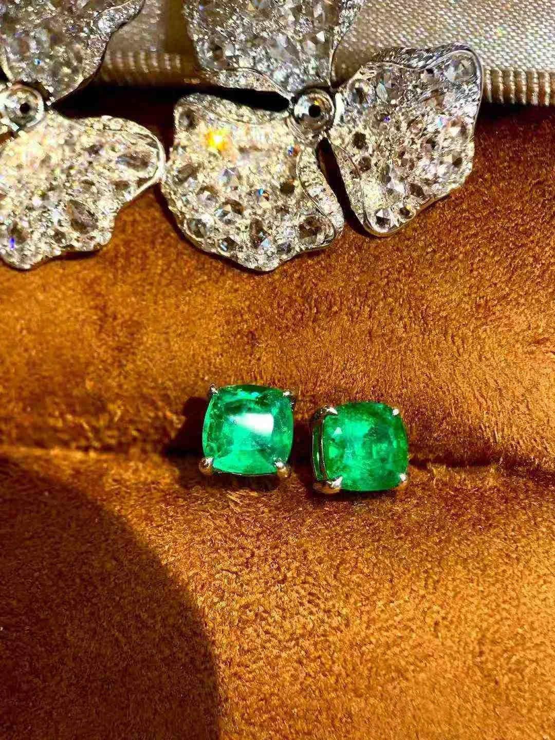 These stunning 2ct emerald flower stud earrings are beautifully designed with 1.40ct of white diamonds and set in luxurious 18K white gold. Each earring features a captivating emerald at the center, surrounded by a halo of brilliant white diamonds