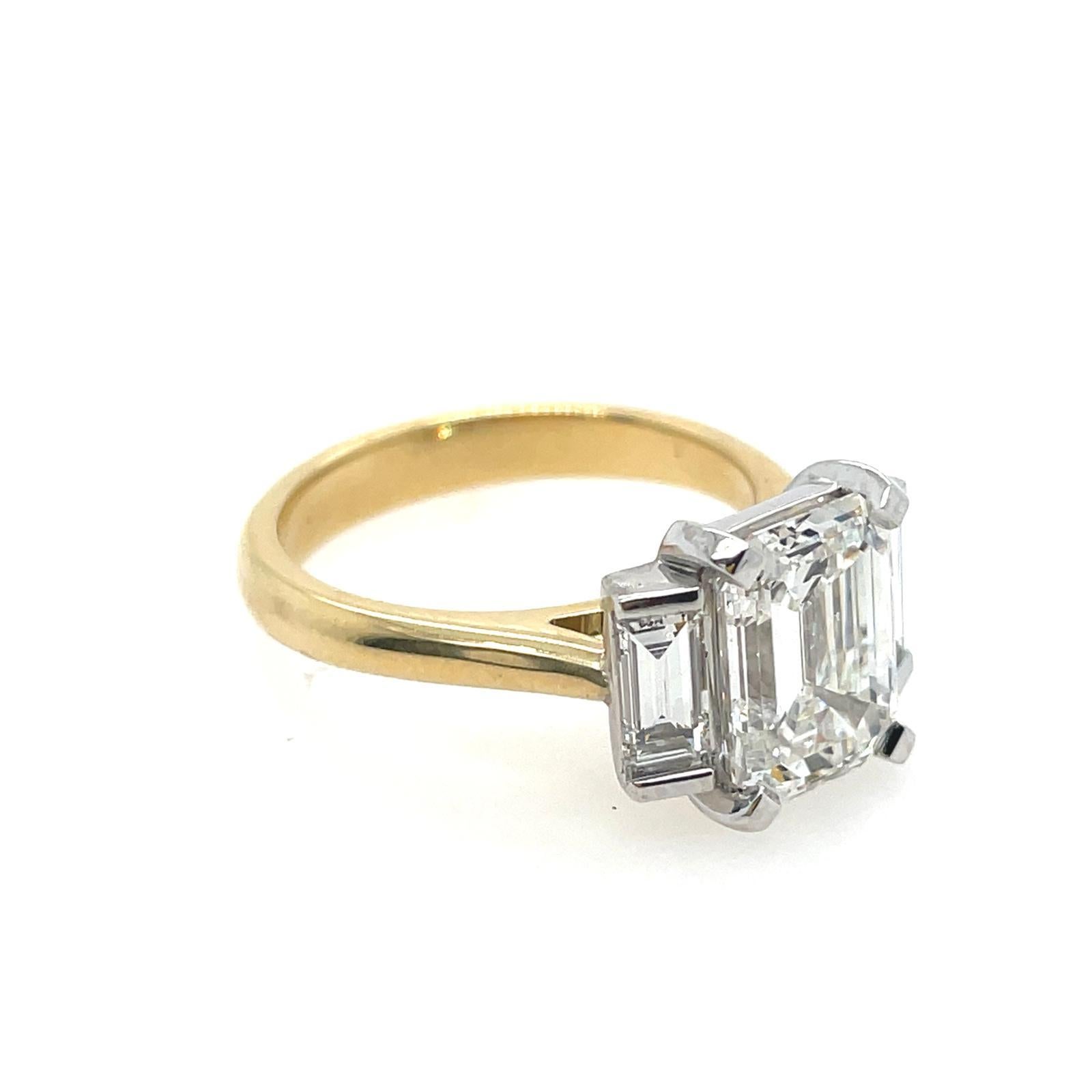 Individuell auf Ihre Fingergröße gefertigt. Dreisteinring aus 18 Karat Weiß- und Gelbgold mit einem weißen Diamanten im Smaragdschliff mit 2 ct. FVS2 (oder einem von Ihnen bevorzugten Grad) und einem Paar Baguette-Diamanten im FVS-Schliff an beiden