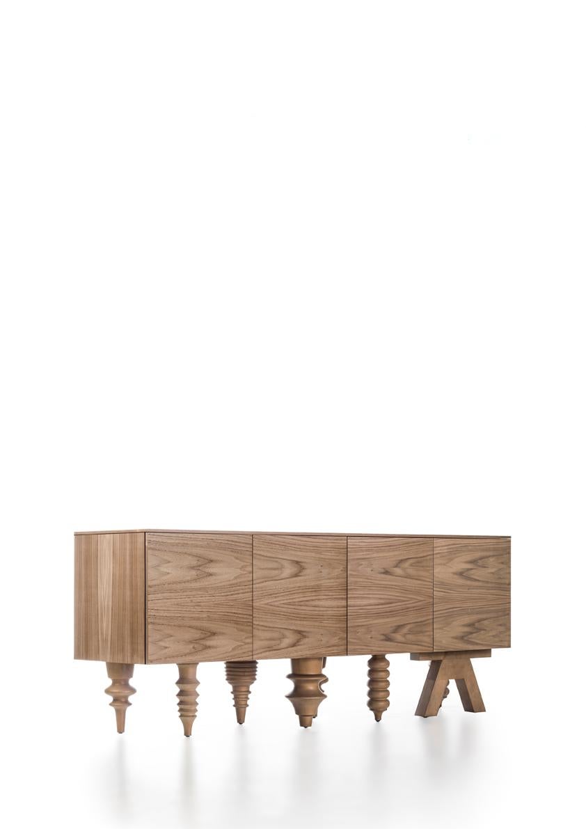 Modules and doors in MDF and walnut effect , The interior finish is walnut Tops: 1cm glass Legs in solid turned alder-wood in Walnut Effect.

Drawers with metalic laterals with lengths of 2M module. The drawer handles are in a brass finish. 


