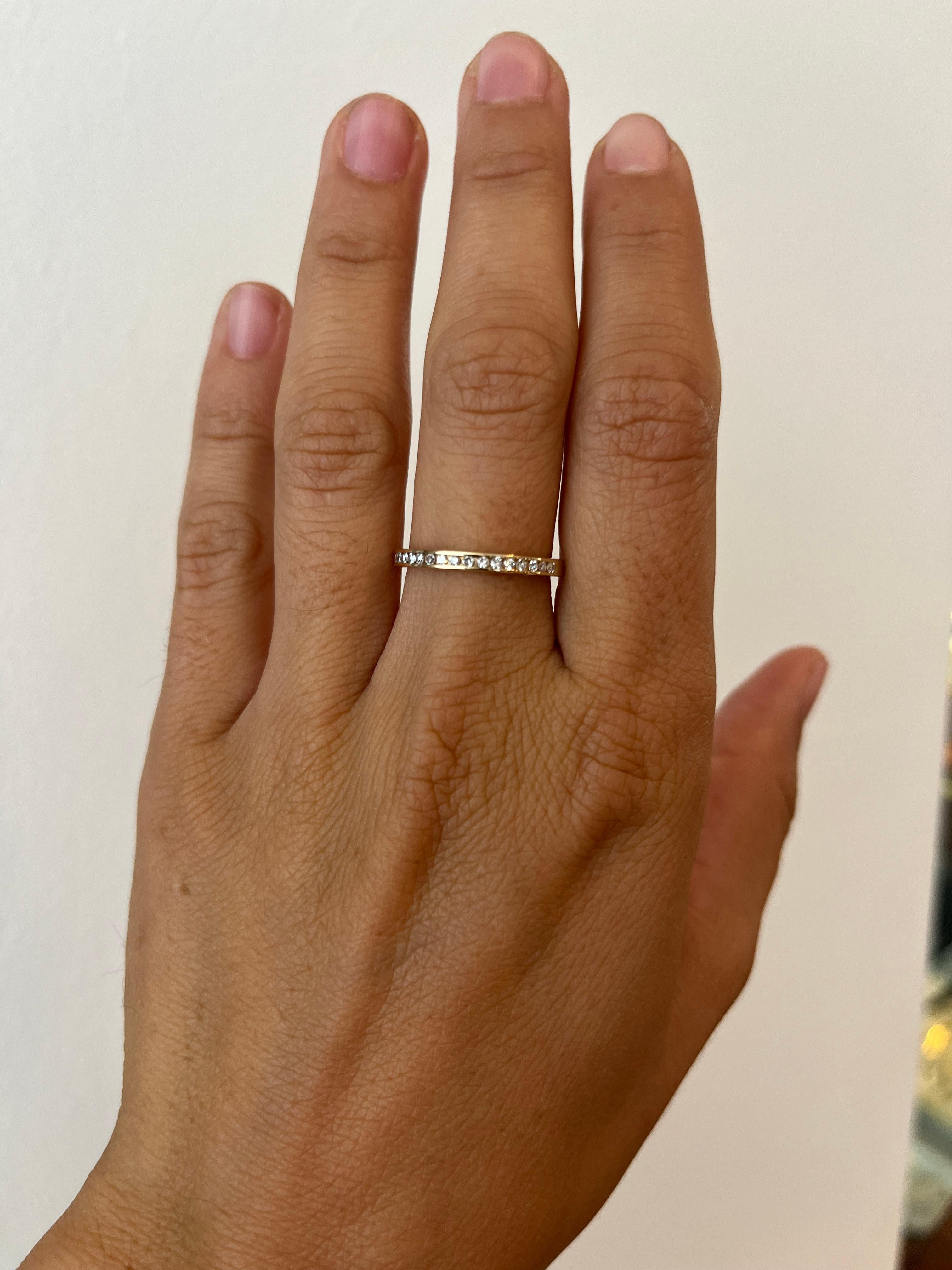 Alianza de boda de media eternidad con diamantes engarzados en oro amarillo de 14 quilates. Su estrecho ancho de 2 mm lo hace perfecto para apilar y todo ello sin renunciar al brillo, ya que incorpora 20 diamantes redondos que suman 0,20 ct. El
