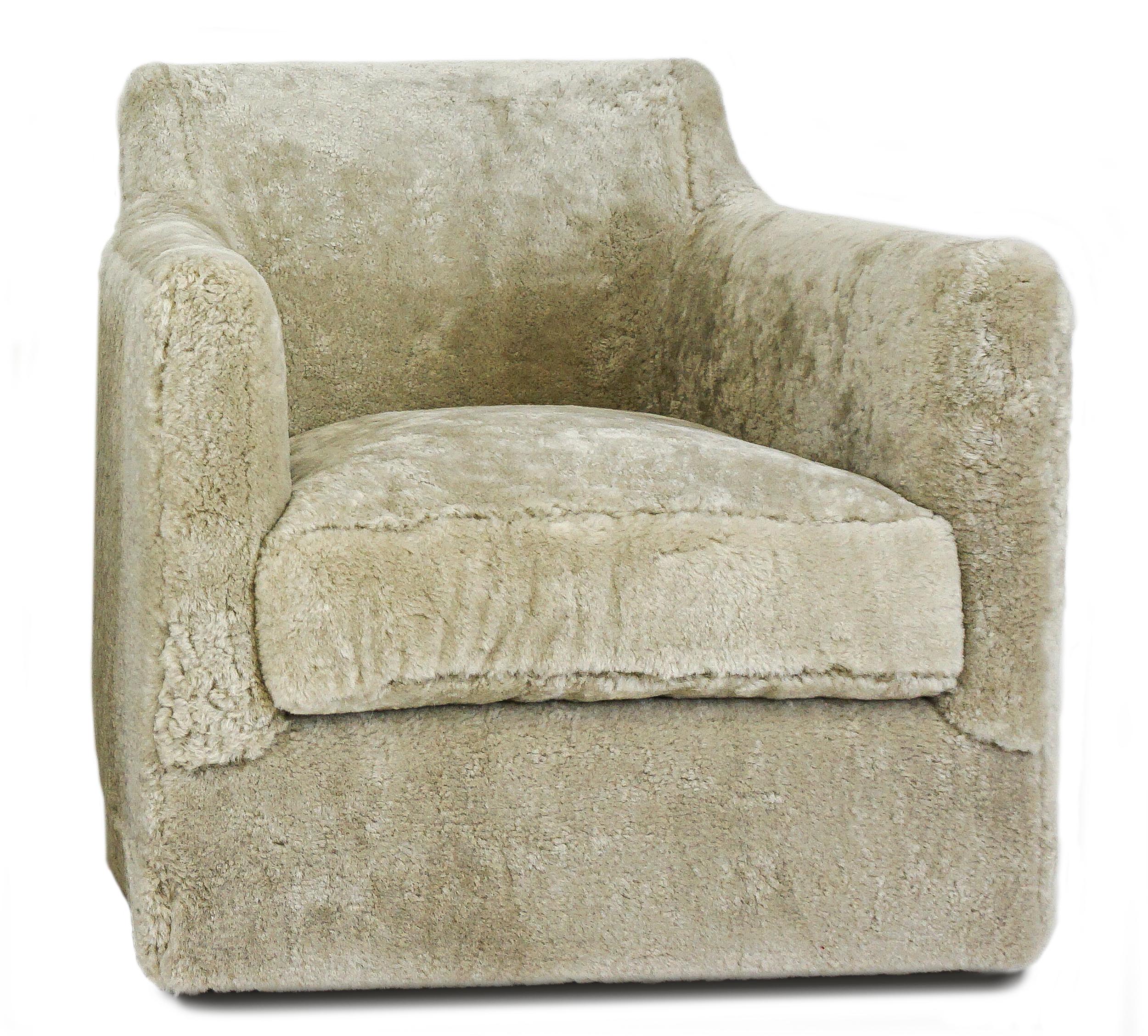 Le fauteuil pivotant Tyler est un modèle de fauteuil pivotant contemporain doté d'accoudoirs courbés vers l'arrière. L'assise à coussin lâche est fabriquée à la main avec de la mousse et une enveloppe de plumes de duvet pour une expérience d'assise