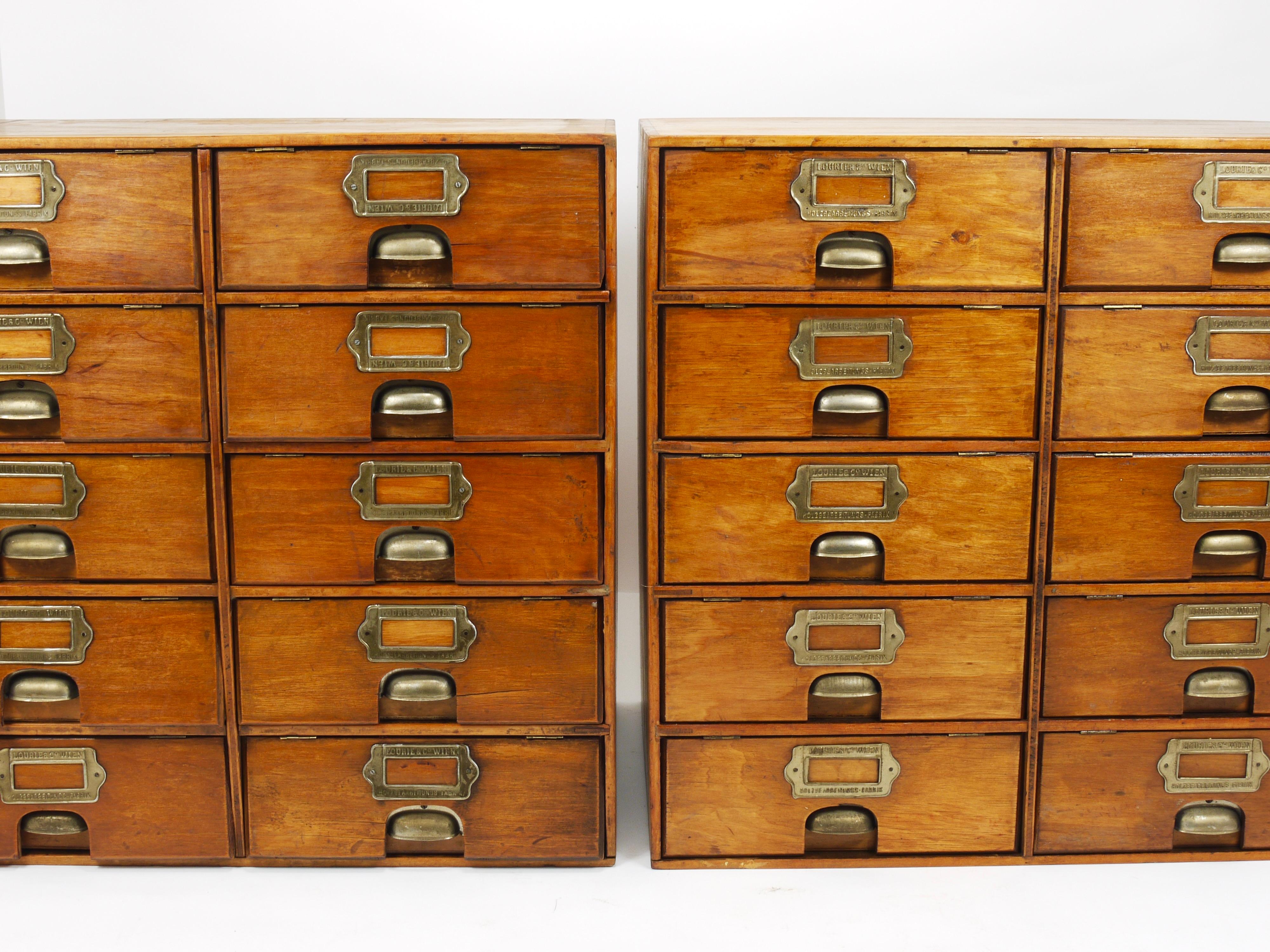 Two identical industrial-style vintage countertop chests of drawers or filing cabinets, dating from around 1910 to 1920, which were priced and sold per piece. Crafted by Lourié & Co, founded in 1899 in Vienna, Austria. These wooden cabinets feature