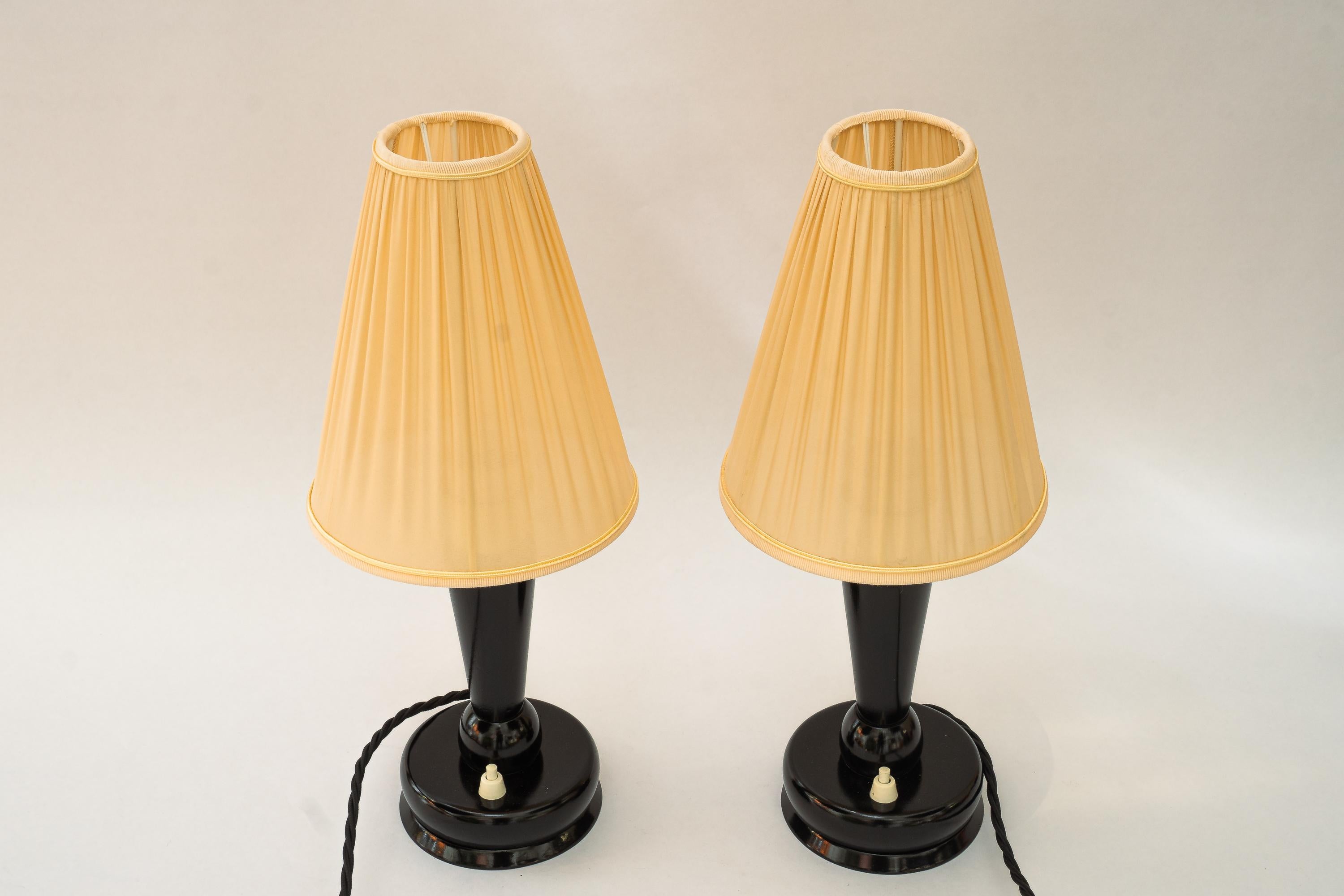 2x lampes de bureau Art déco avec abat-jour en tissu viennoise vers les années 1920 
Bois laqué
Laiton poli et émaillé au four
Les stores en tissu sont remplacés (neufs).