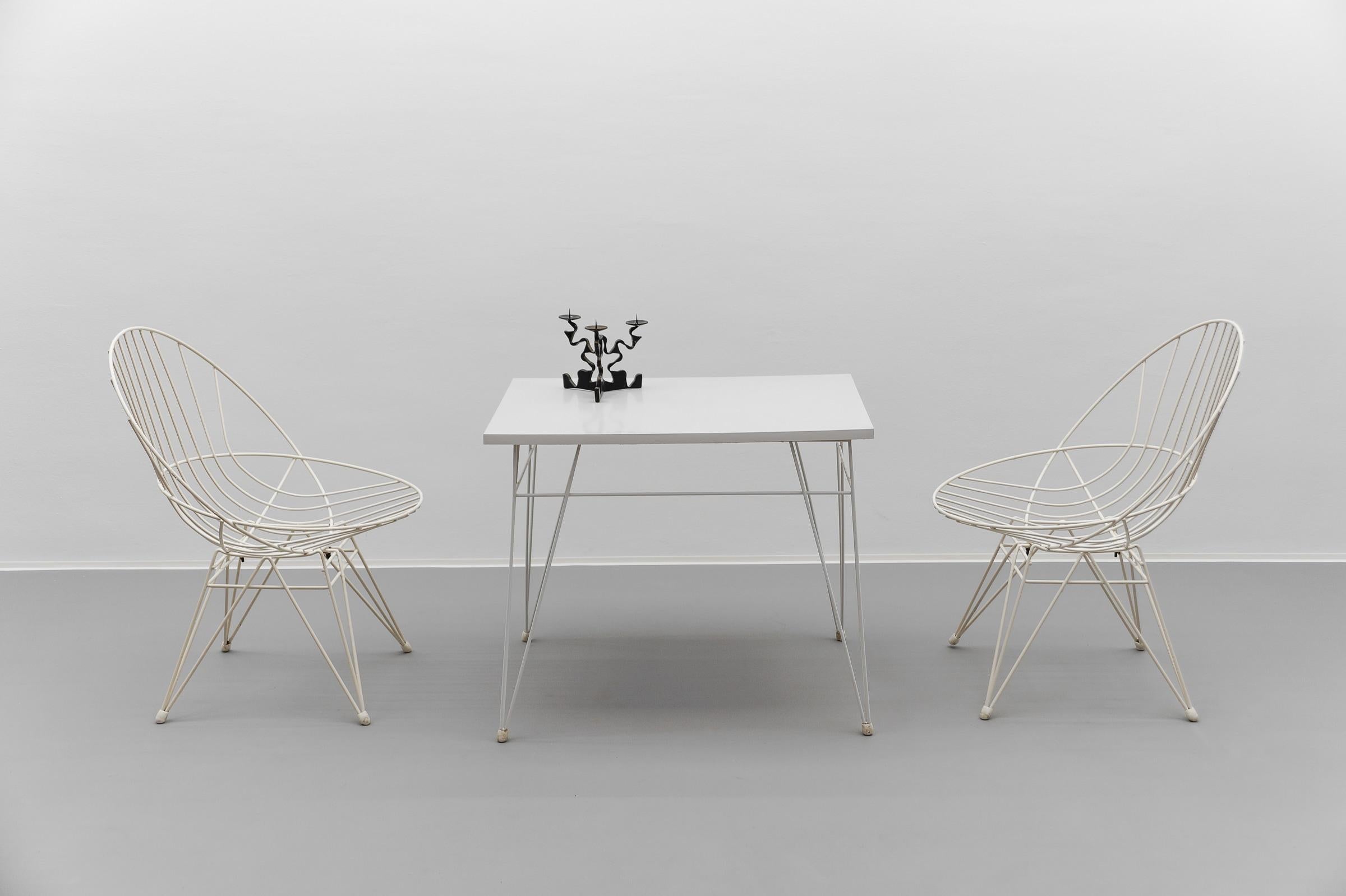 Ensemble absolument rare composé de deux chaises et d'une table basse.

En bon à très bon état avec de légers signes d'usure, quelques petits manques sur les chaises, voir photos.

Fauteuil : hauteur d'assise 40cm, hauteur 78cm. Largeur 59 cm,