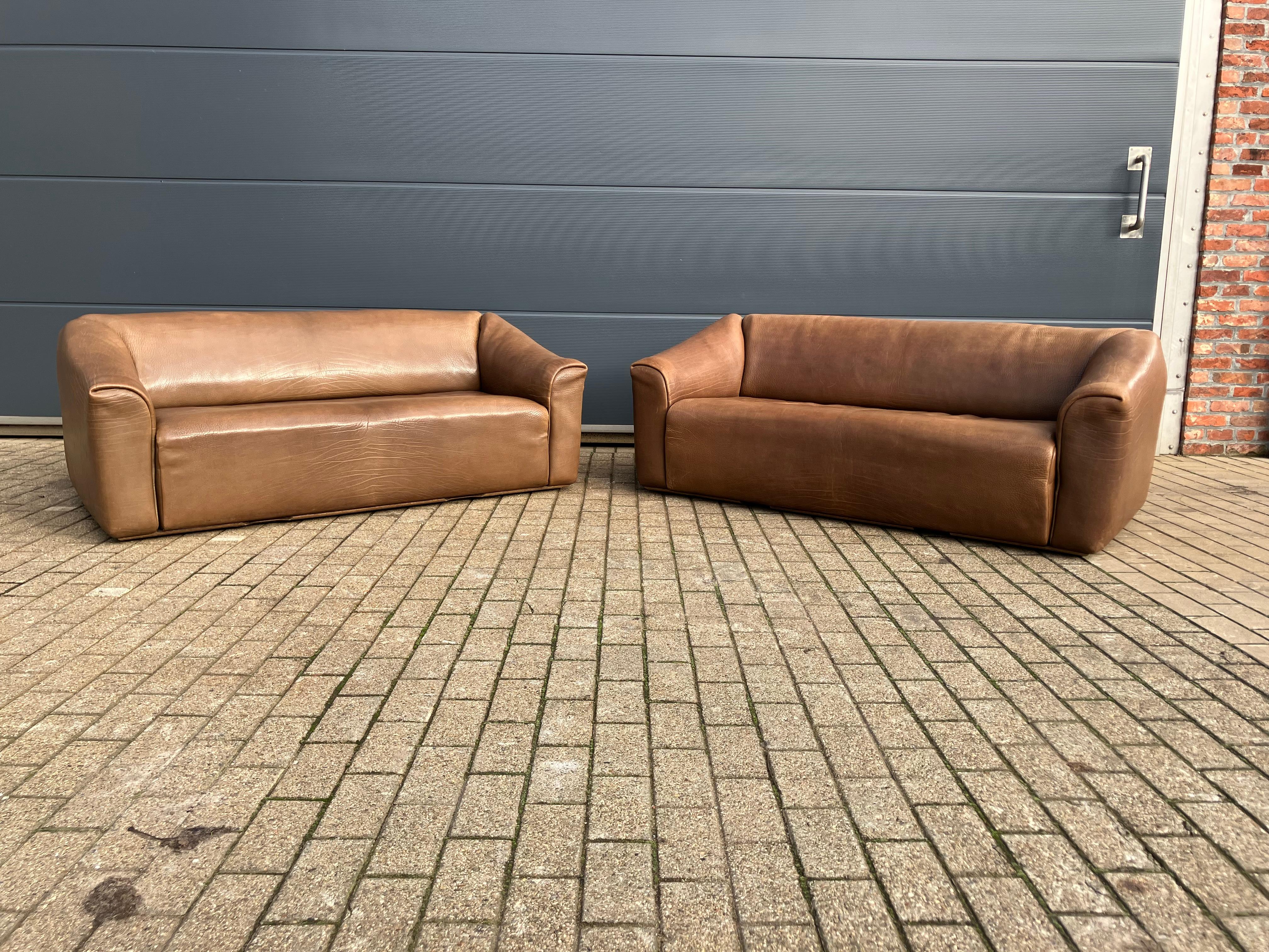 Design classic from the Swiss top brand De Sede. Made of the typical indestructible 5mm thick NECK leather (Nappa natural leather). Top quality!

Color: Light brown, Cognac

Both couches are in top condition without dark discoloration! Were always