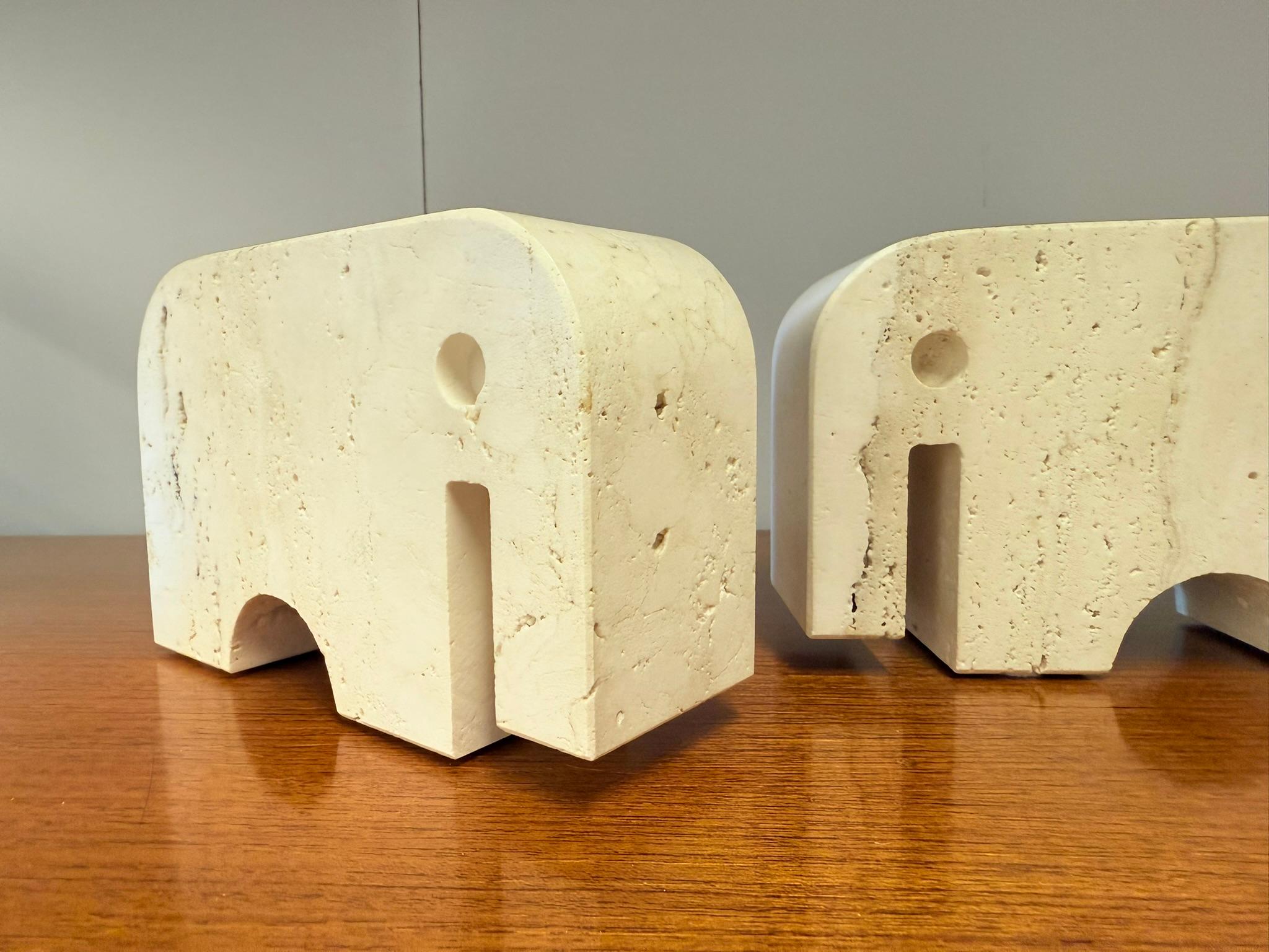Bellissima coppia di fermalibri scultorei in marmo travertino, realizzati a forma di due elefanti stilizzati. Disegnata da Enzo Mari e prodotta dai Fratelli Mannelli negli anni '70 in Italia.

Il travertino naturale conferisce a ogni pezzo una