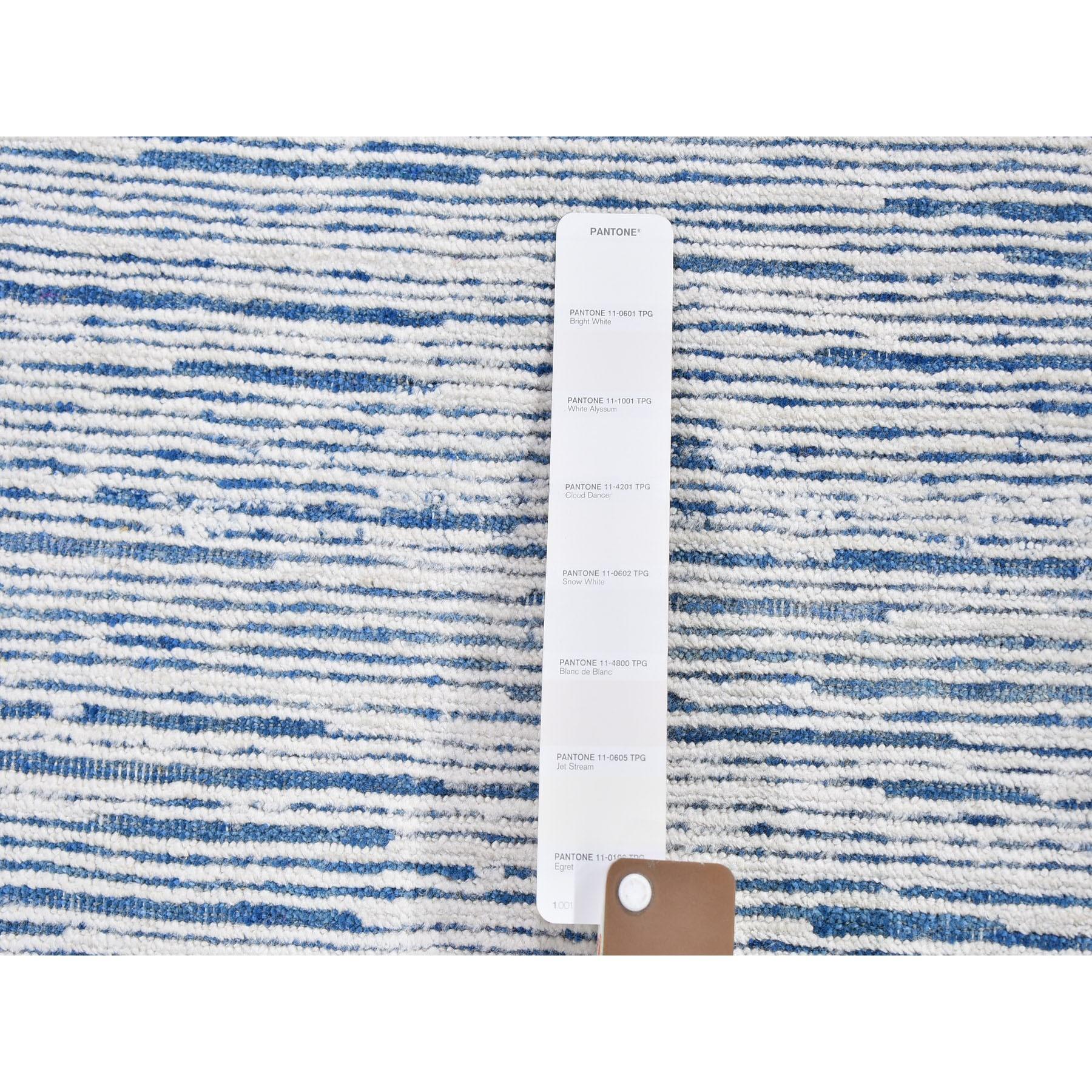 Il s'agit d'un véritable tapis oriental noué à la main, unique en son genre, composé de soie bleue et de laine texturée à motifs de rayures. Il a été tissé pendant des mois et des mois selon les techniques séculaires de l'artisanat persan par des
