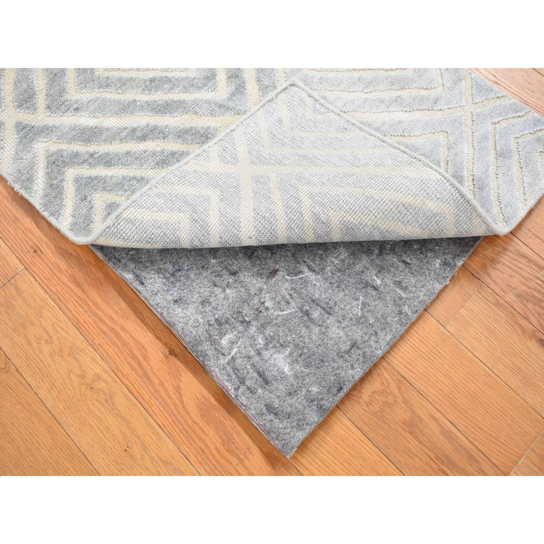 Il s'agit d'un véritable tapis d'Orient gris clair, au design moderne, en soie et laine texturée, noué à la main en partie haute et en partie basse. Il a été noué pendant des mois et des mois selon des techniques de tissage séculaires par des
